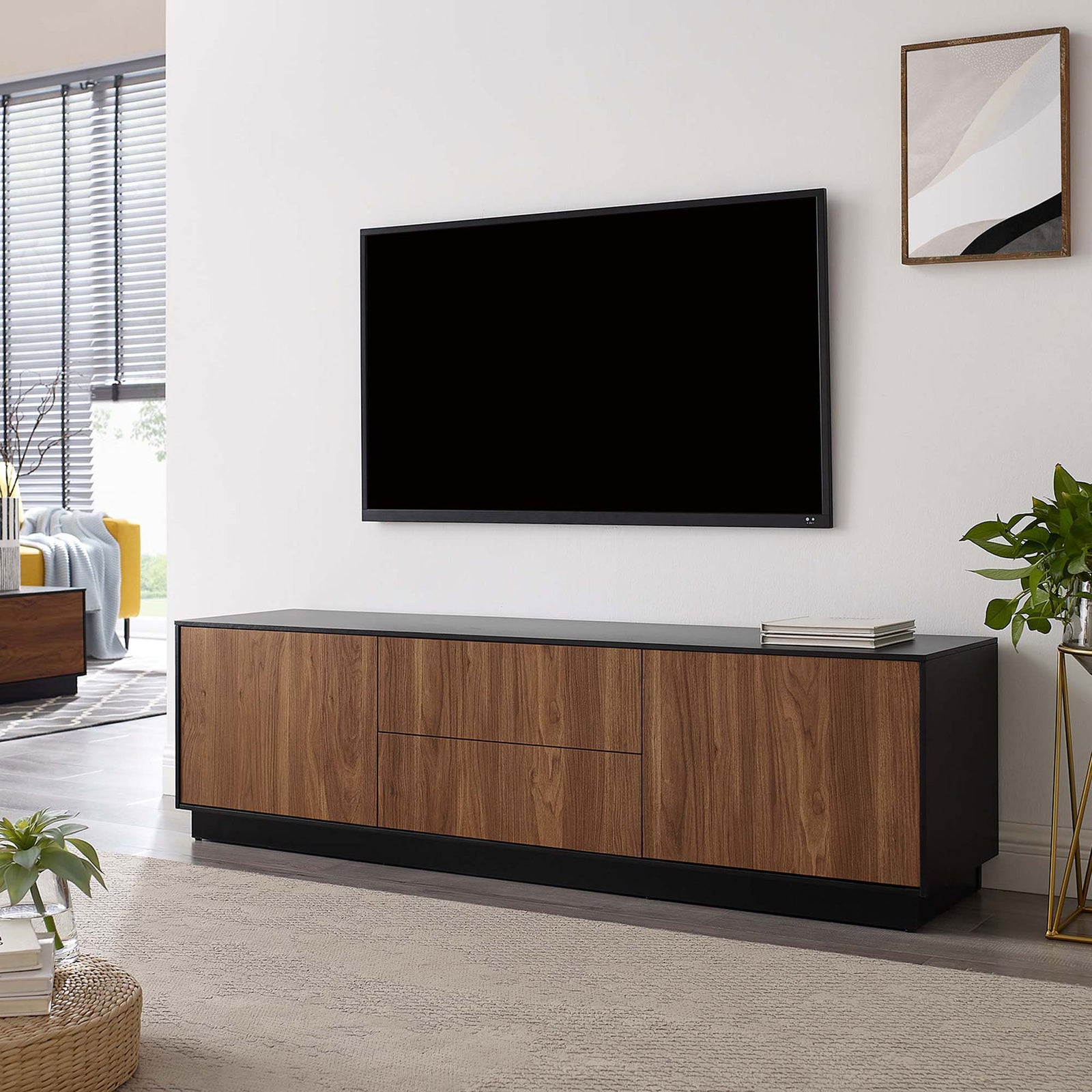 Holden TV stand in a contemporary living space supporting a wall-mounted television || EEI-6598-BLK-WAL || front_angle_room