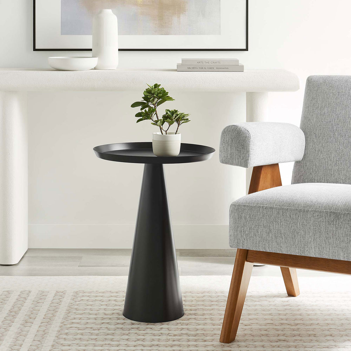 Maren round side table in black adds a bold sculptural accent beside contemporary living room seating || EEI-6608-BLK || front_room