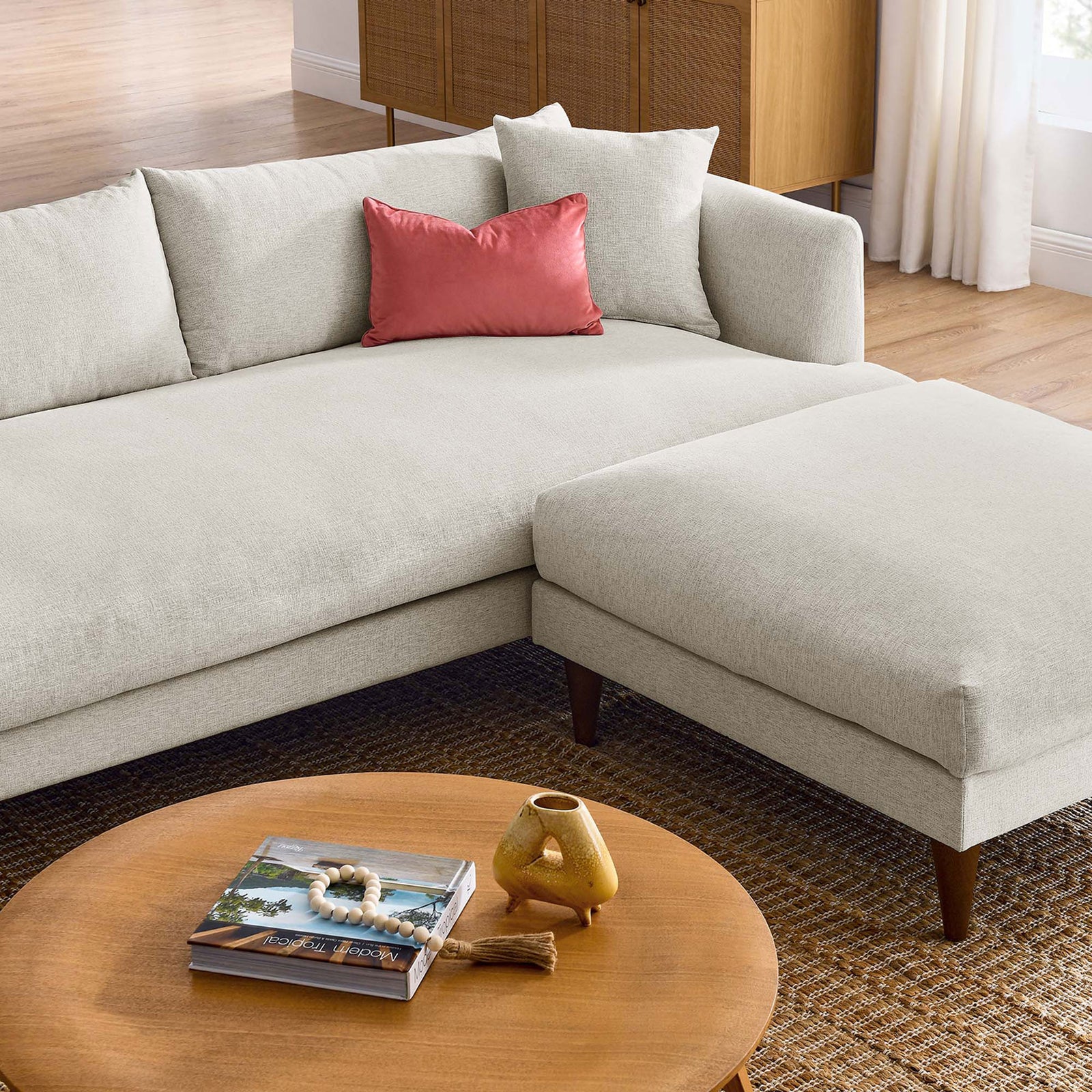 Cozy corner of the ivory sofa and ottoman styled with a warm wood coffee table and decor || EEI-6614-HEI || detail_room