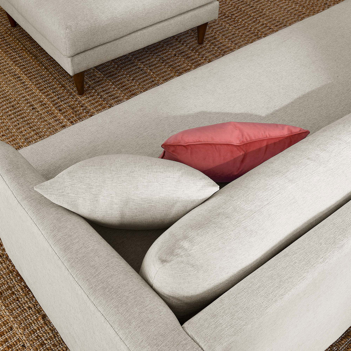 Overstuffed ivory sofa back cushions styled with colorful accent pillows on a textured rug || EEI-6614-HEI || detail_room