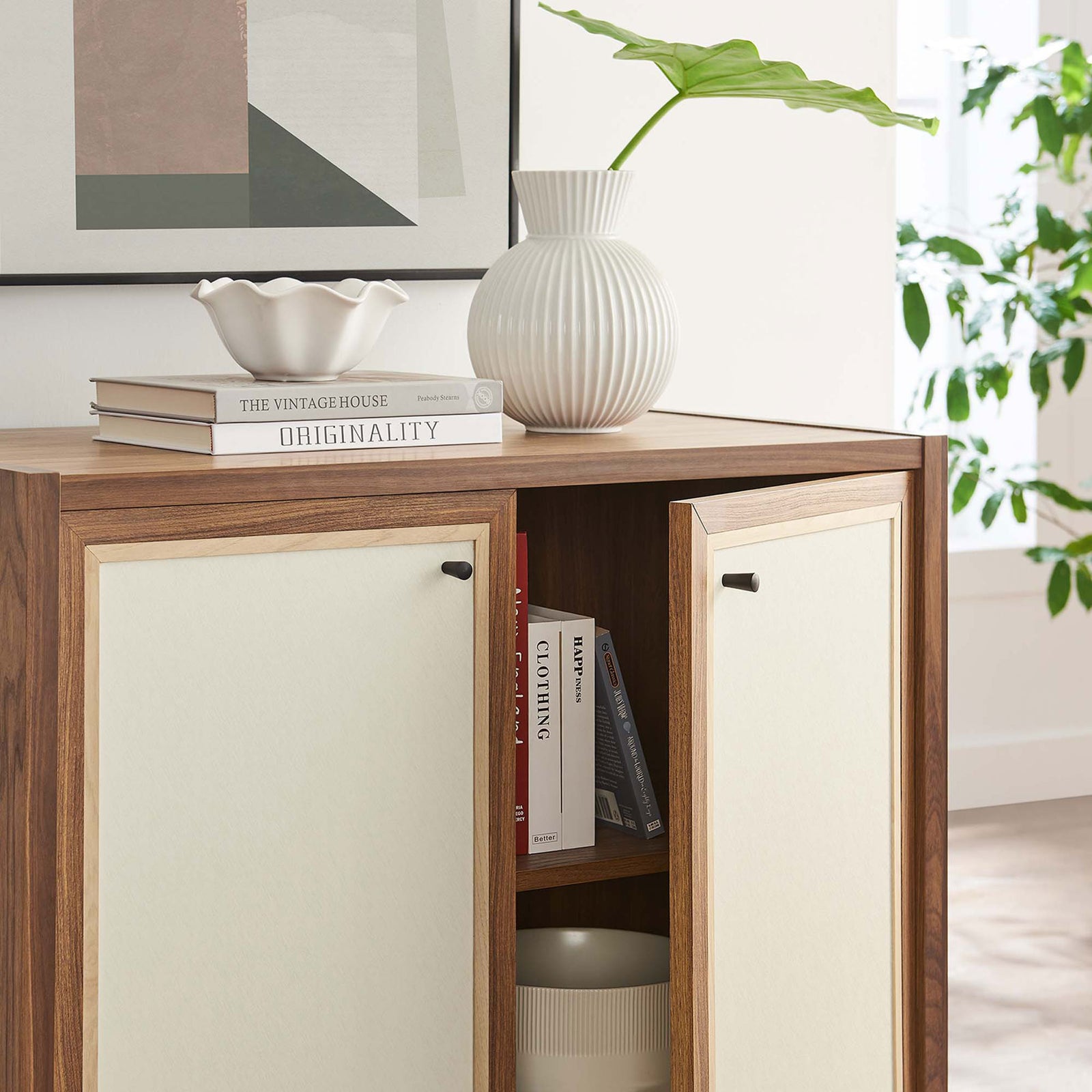 Cabinet shown in use with one door open displaying books, bowls, and decorative storage || EEI-6615-WAL || storage_open_room