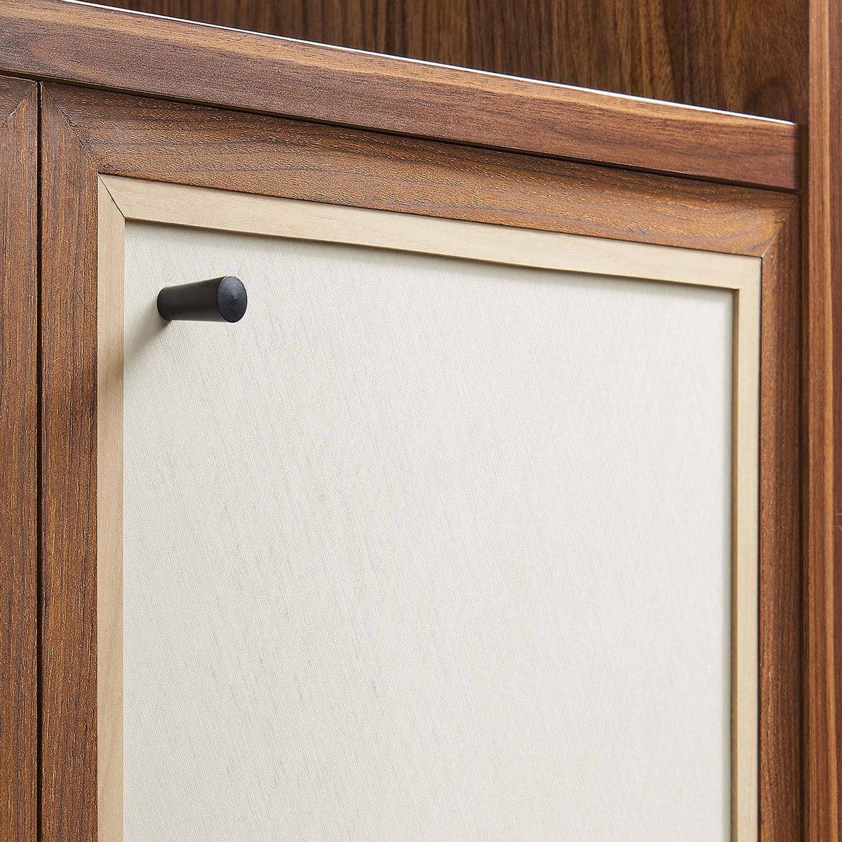 Linen-textured cabinet door accented by a sleek round matte black knob || EEI-6619-WAL || handle_studio