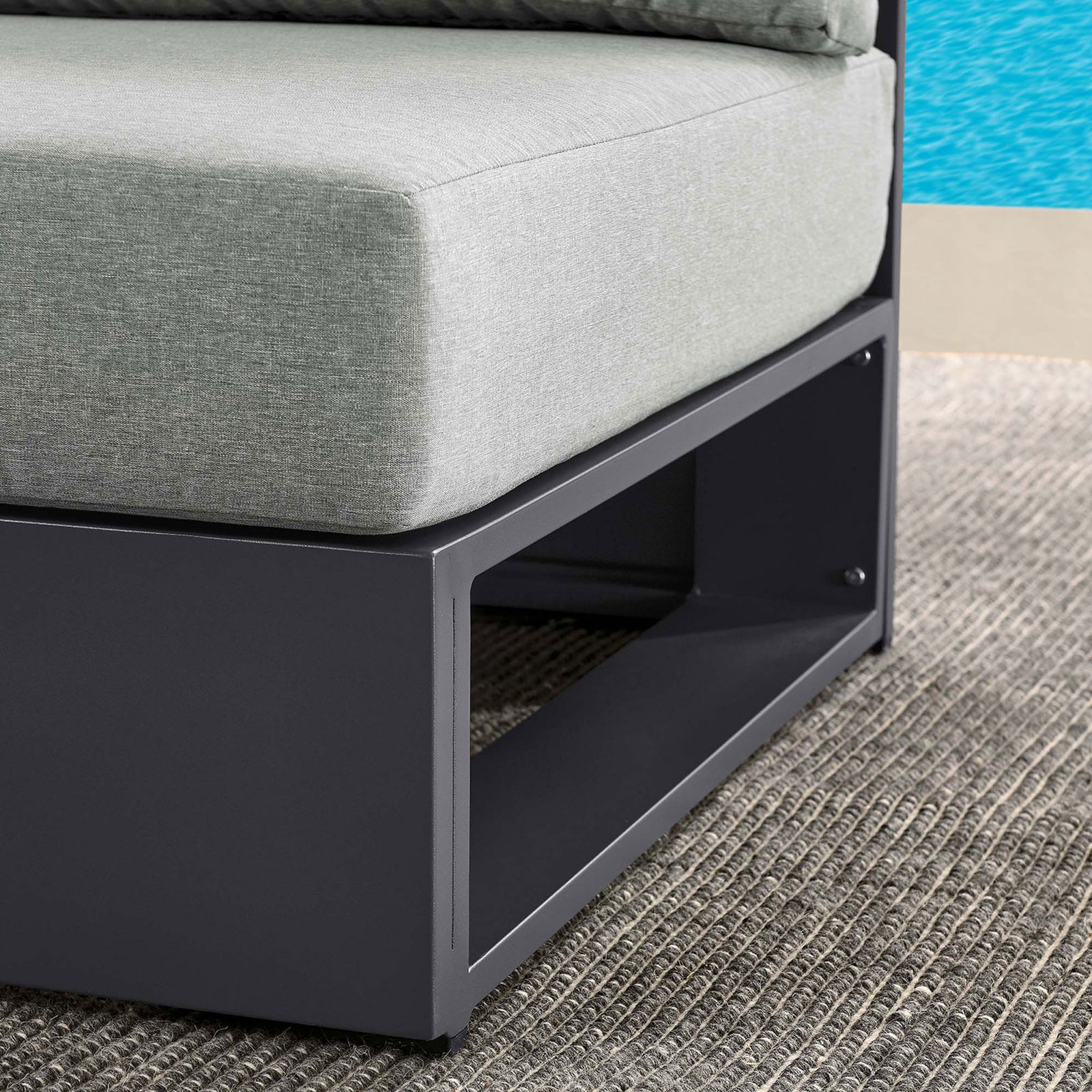 Light gray cushion and charcoal base of Tahoe armless chair styled on an outdoor rug beside a clear blue pool || EEI-6628-GRY-GRY || detail_room