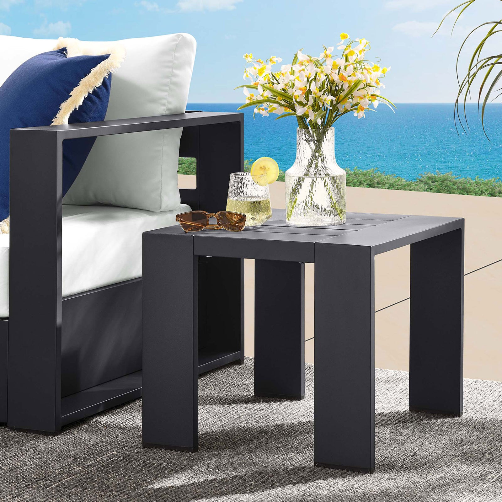 Gray aluminum side table beside an outdoor lounge chair, ideal for drinks, decor, and everyday patio use. || EEI-6635-GRY || front_angle_room