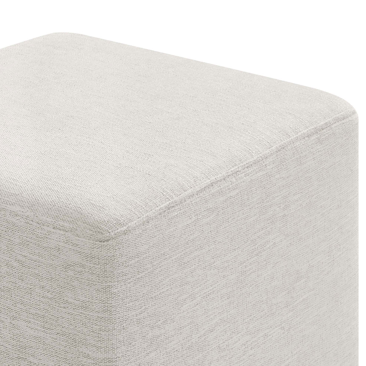 Close-up of the ottoman corner showing the textured heathered ivory upholstery and tailored seams. || EEI-6636-HEI || detail_studio