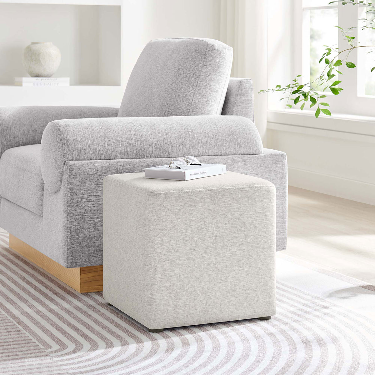 Ivory cube ottoman paired with a modern sofa, adding a versatile accent seat or footrest to the living room. || EEI-6636-HEI || front_angle_room