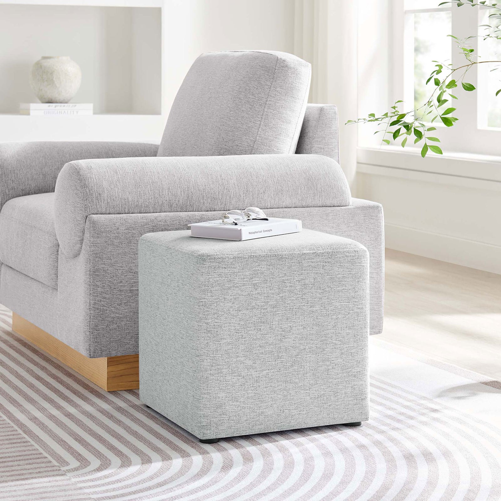 Light gray ottoman paired with a matching sofa, serving as a sleek side table in a bright living room || EEI-6636-HLG || front_angle_room