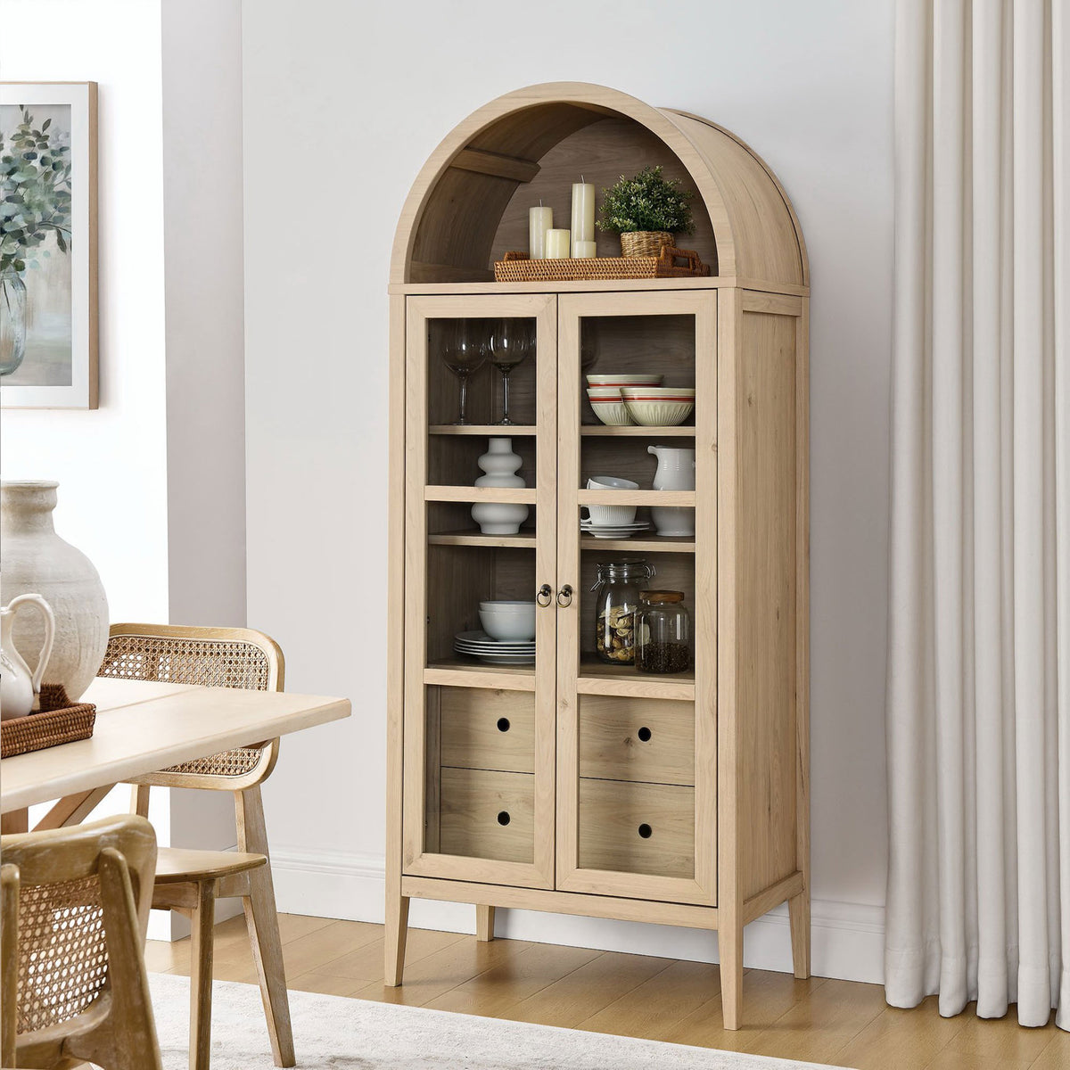 Light oak arched cabinet styled with glassware and baskets in a contemporary dining room || EEI-6639-LOA || front_angle_room