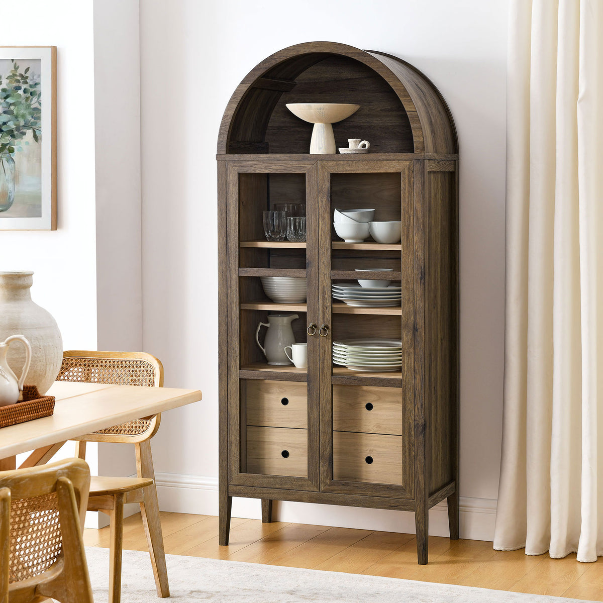 Walnut hickory arched cabinet styled with dishes and vases in a light filled dining nook || EEI-6639-WAL-HCK || front_angle_room