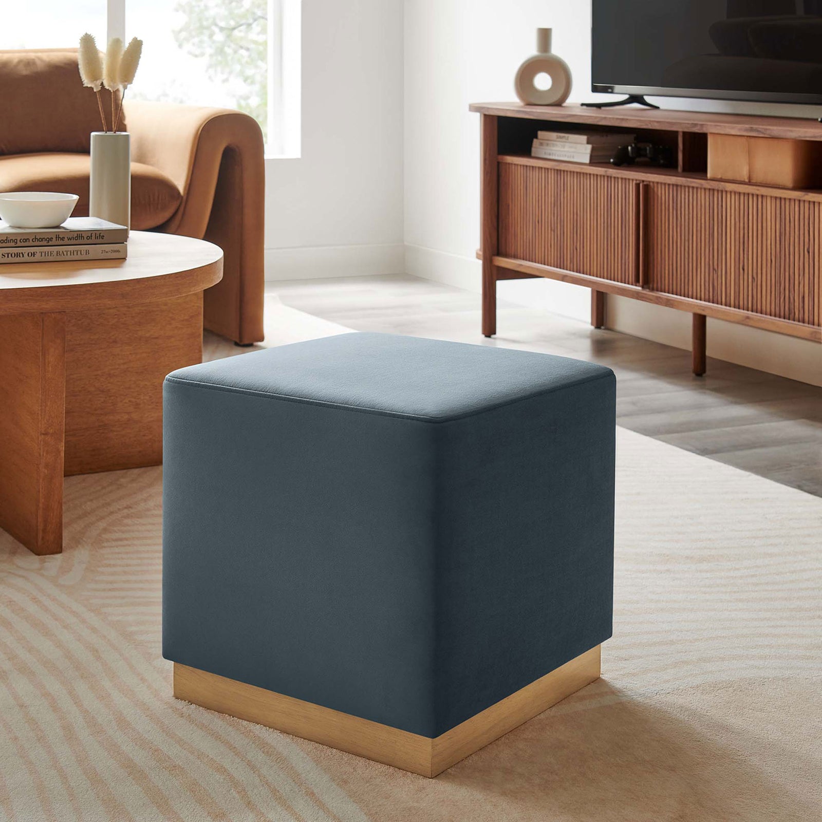 Cadet blue velvet ottoman anchors a warm mid-century living space with soft texture and modern lines. || EEI-6640-CAB-NAT || front_angle_room