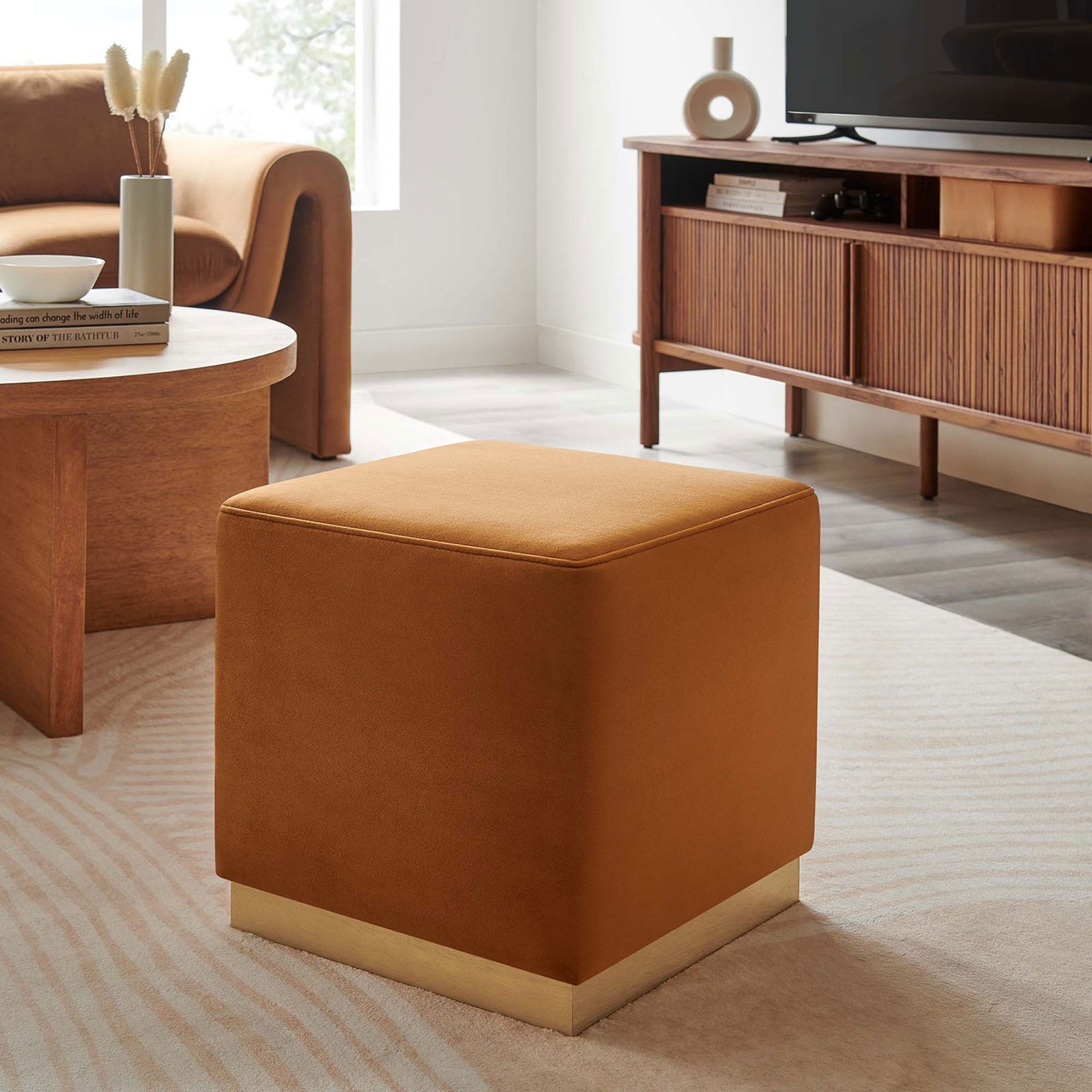 Rust velvet ottoman adding warm color to a modern living room with wood furniture and soft rug || EEI-6640-RUS-NAT || front_angle_room