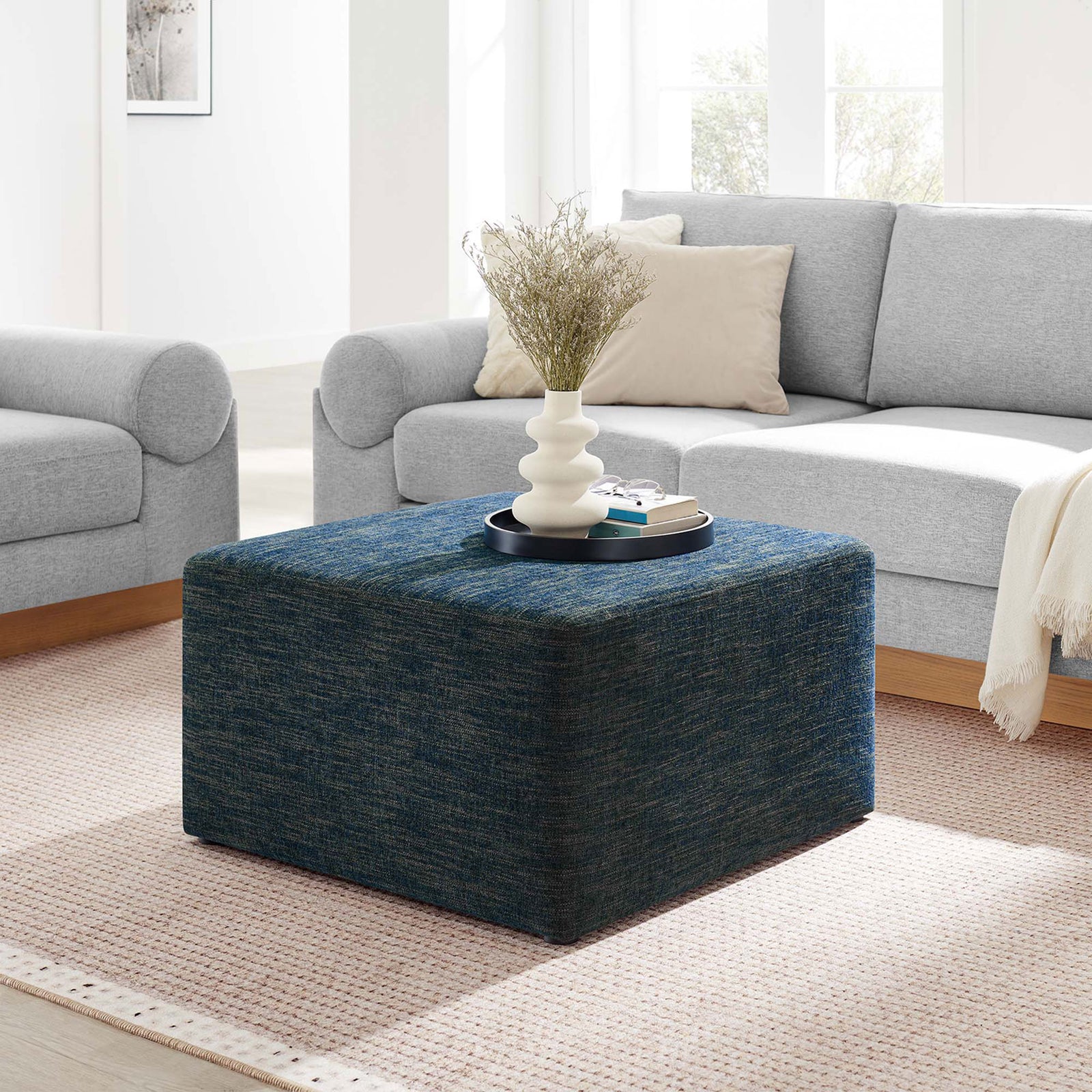Heathered azure ottoman pairs effortlessly with light sofas, serving as a soft, versatile coffee table. || EEI-6642-HEA || front_angle_room