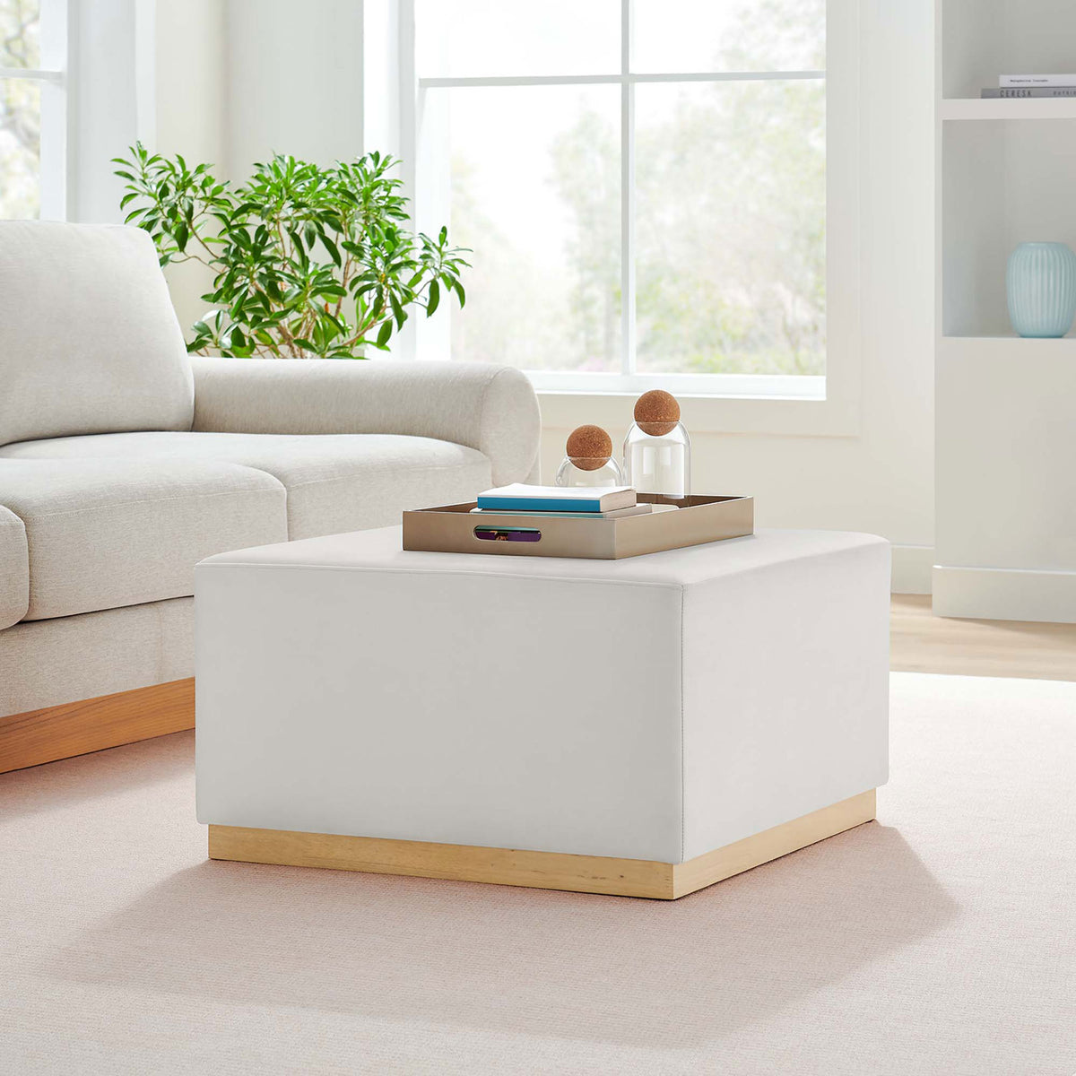 Modern ottoman anchors a bright living room, pairing alabaster upholstery with a light wood base || EEI-6643-ALA-NAT || front_angle_room