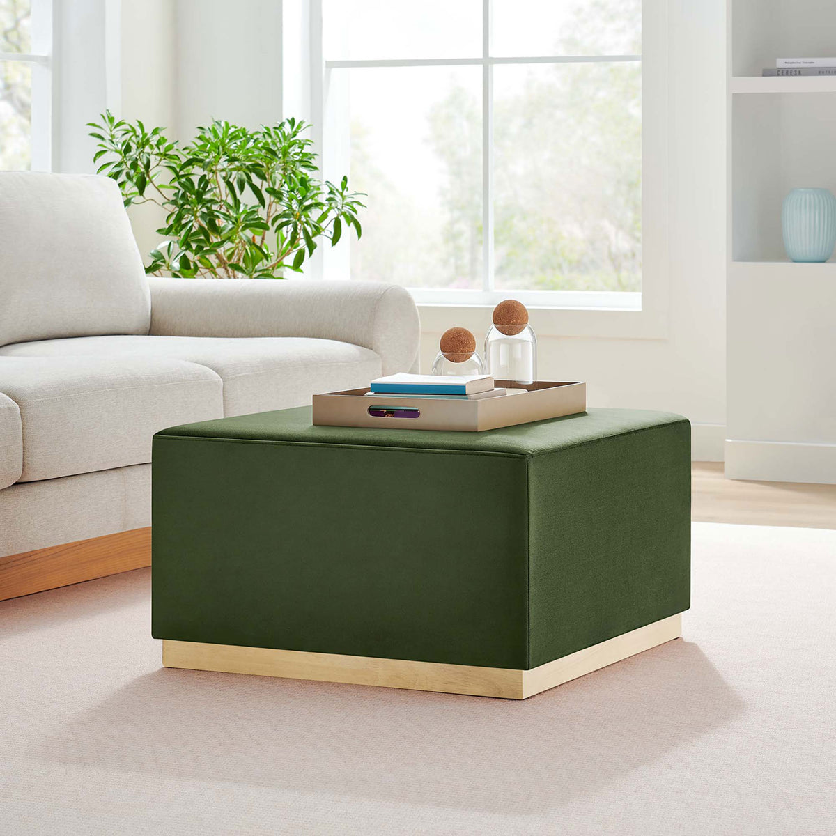 Moss green velvet ottoman centers a bright modern living room, pairing naturally with neutral sofa and greenery || EEI-6643-MOG-NAT || front_angle_room