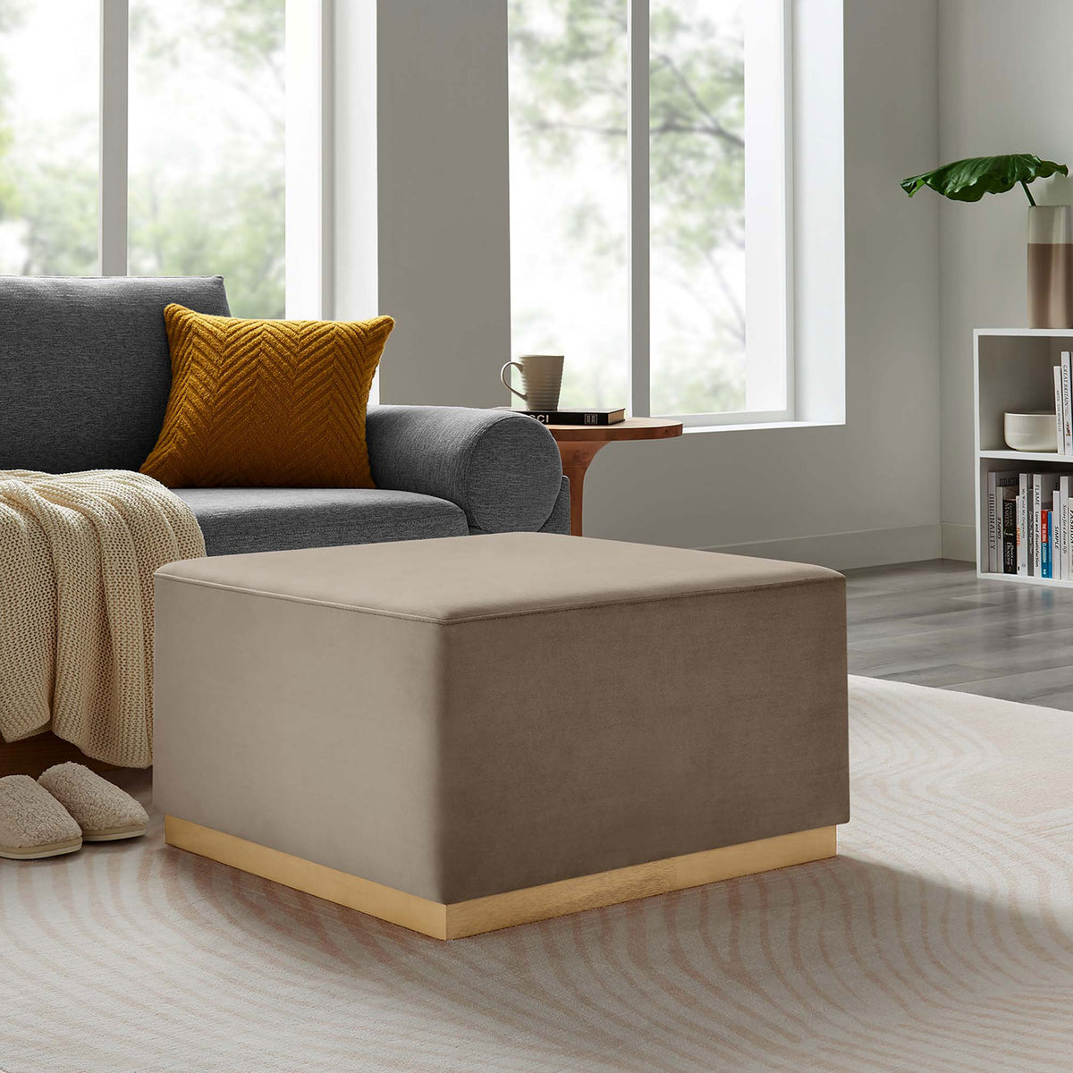 Taupe performance velvet ottoman with wood base paired with sofa and accent decor in a cozy living space || EEI-6643-TAU-NAT || front_angle_room
