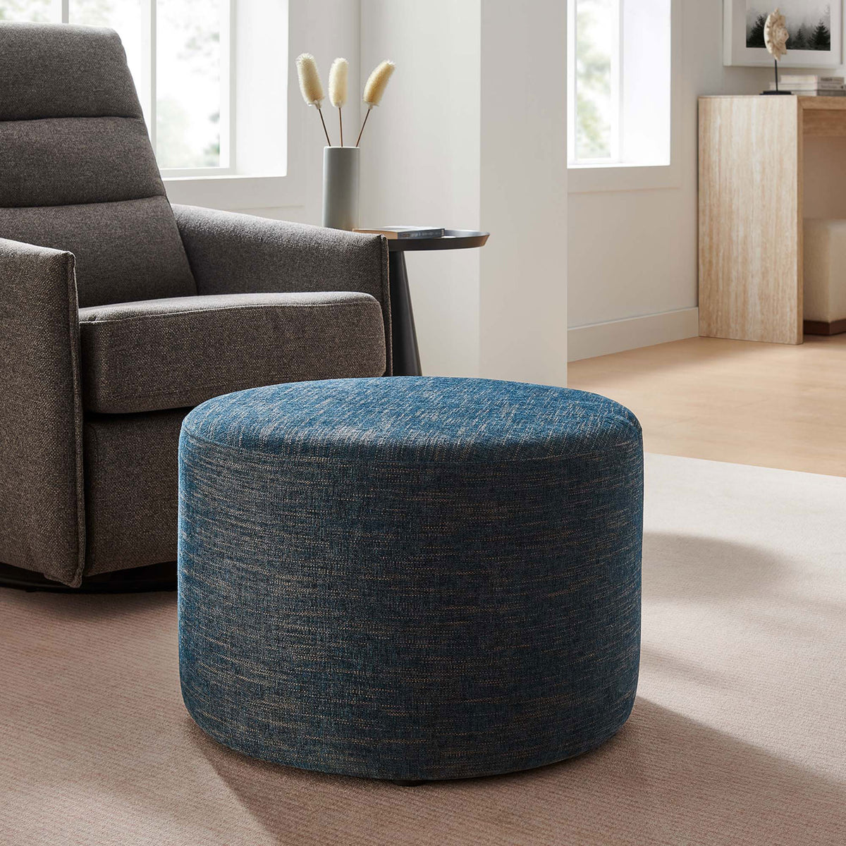 Azure fabric ottoman complements modern seating, offering a soft landing spot in a cozy lounge corner || EEI-6645-HEA || front_angle_room