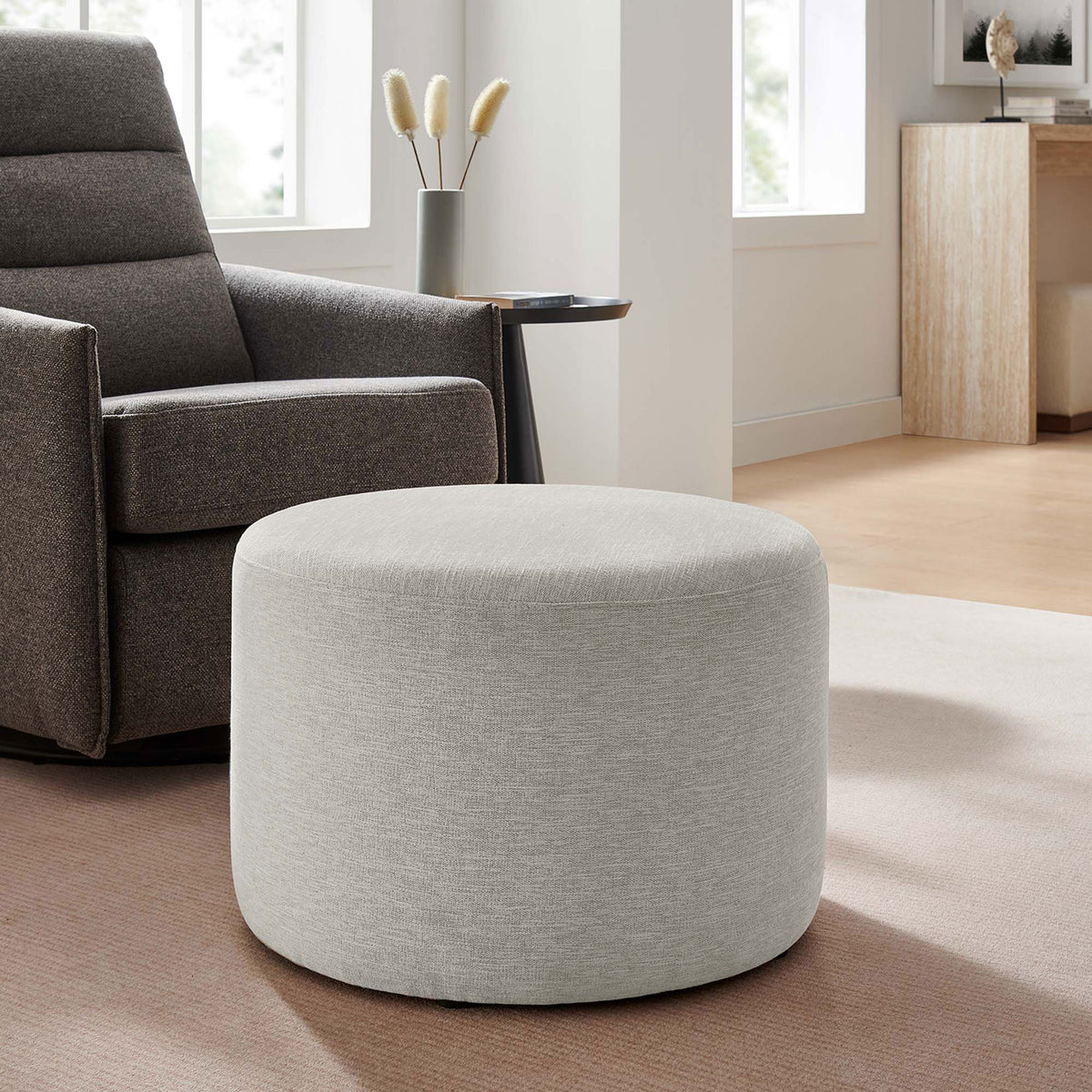 Ivory round ottoman paired with a recliner chair as a versatile footrest in a cozy living space || EEI-6645-HEI || front_angle_room