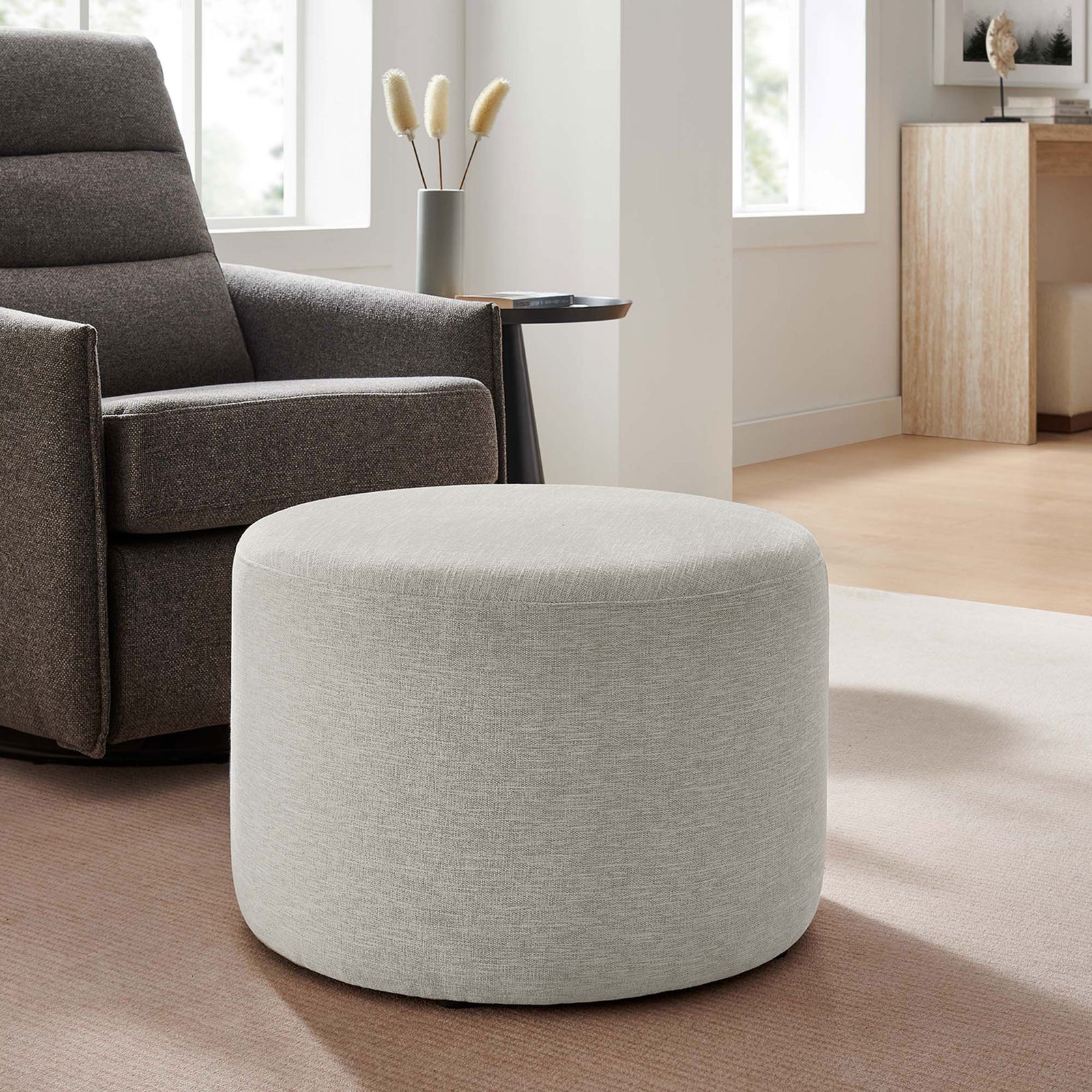 Ivory round ottoman paired with a recliner chair as a versatile footrest in a cozy living space || EEI-6645-HEI || front_angle_room