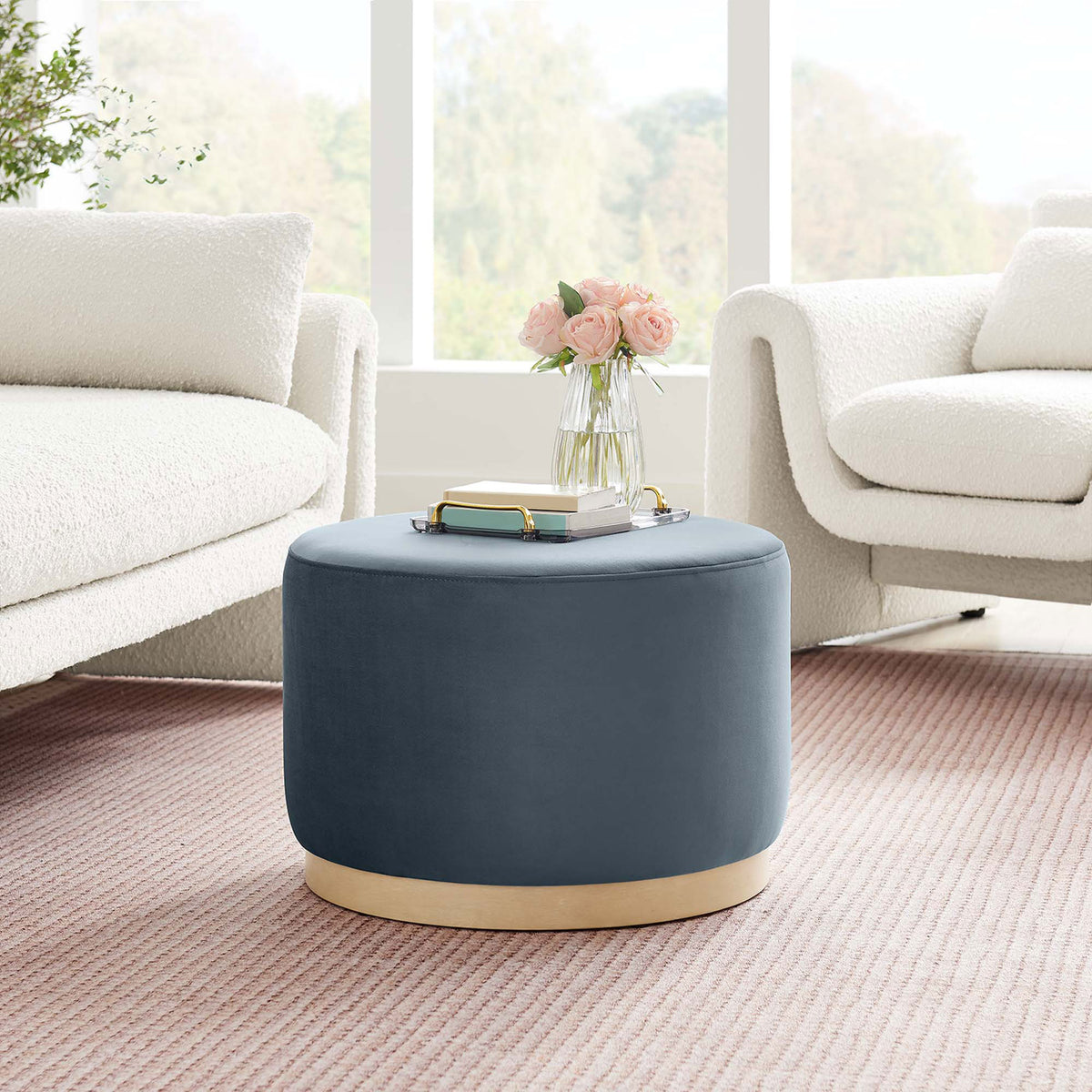 Blue velvet round ottoman with natural wood base bringing modern contrast to a light airy living room || EEI-6646-CAB-NAT || front_angle_room