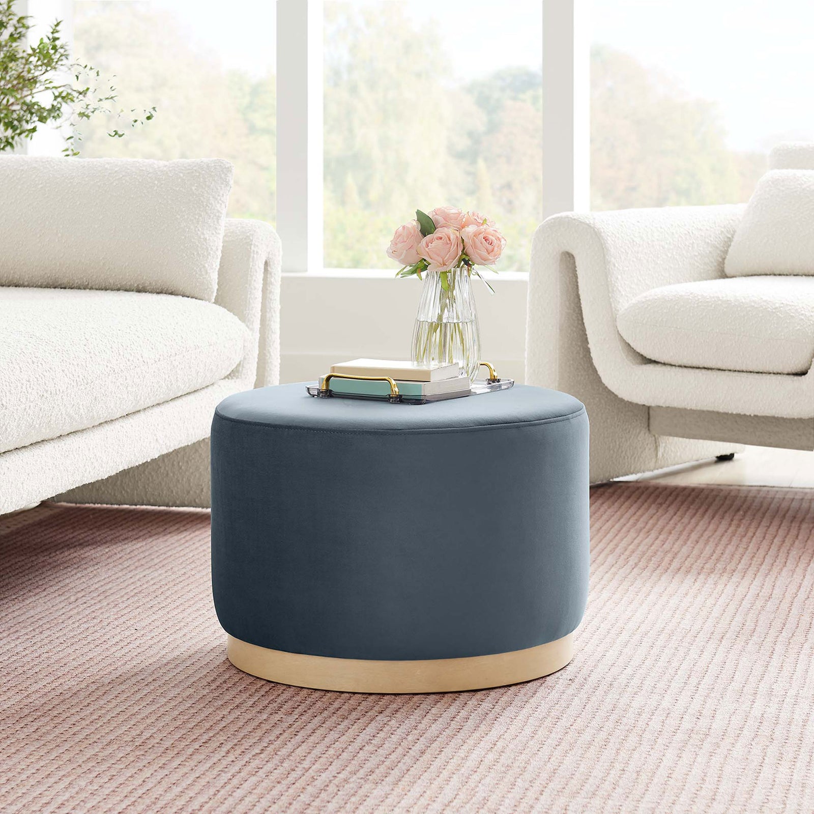 Blue velvet round ottoman with natural wood base bringing modern contrast to a light airy living room || EEI-6646-CAB-NAT || front_angle_room