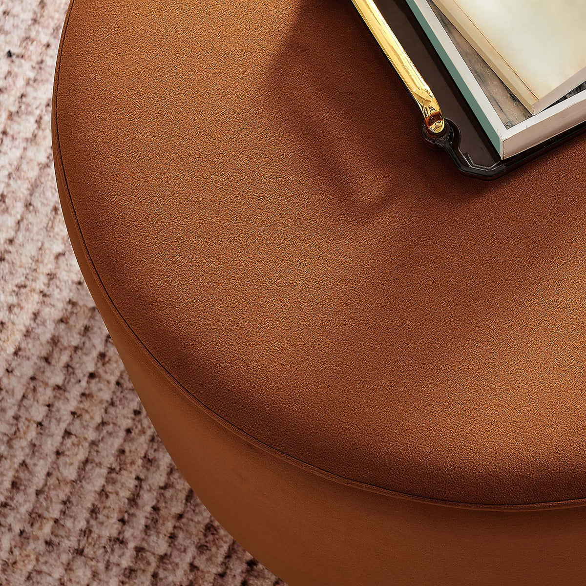 Rust velvet ottoman doubles as a chic coffee table styled with books and decor on a textured rug || EEI-6646-RUS-NAT || detail_room