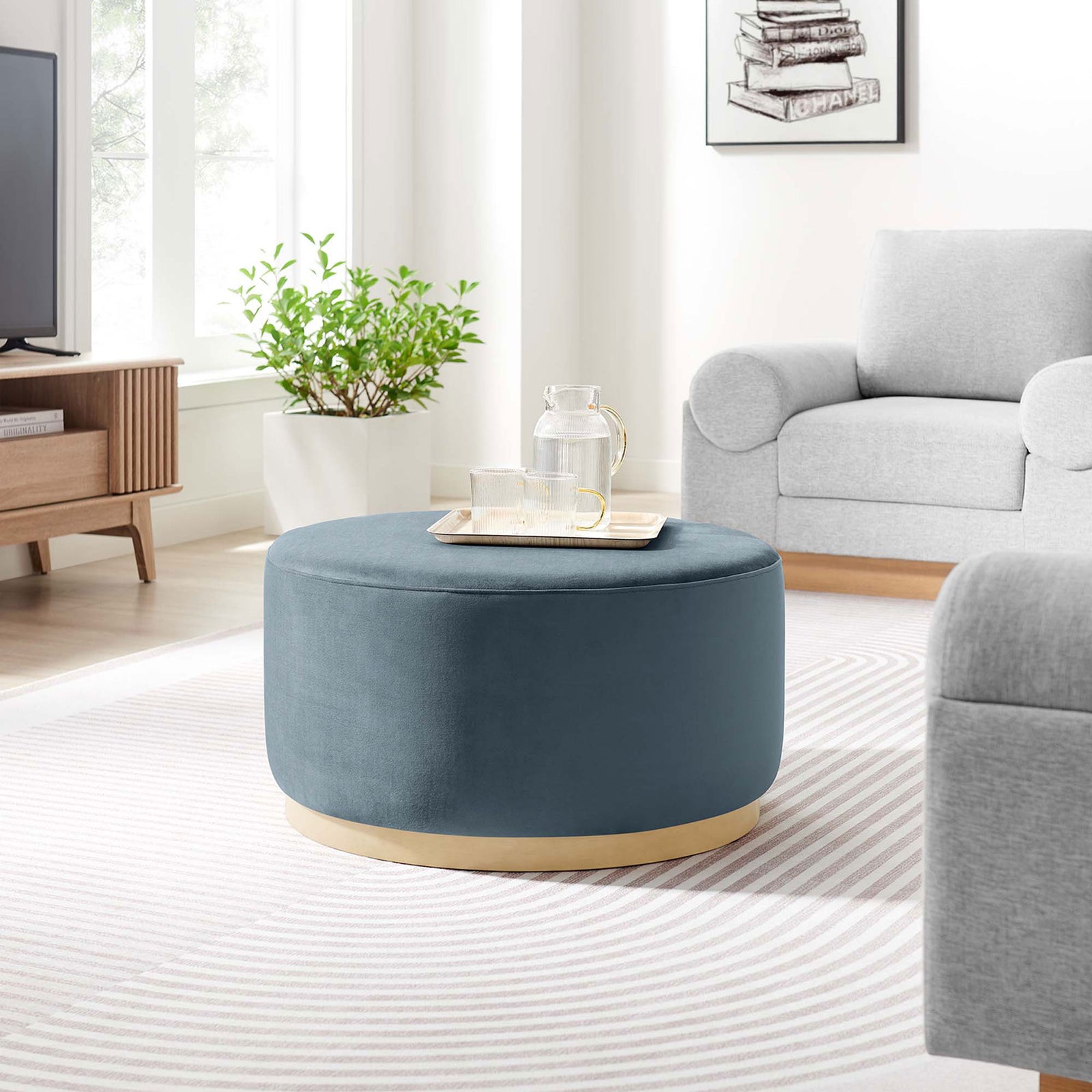 Cadet blue round ottoman with natural base styled in a modern living room as a versatile coffee table || EEI-6648-CAB-NAT || front_room