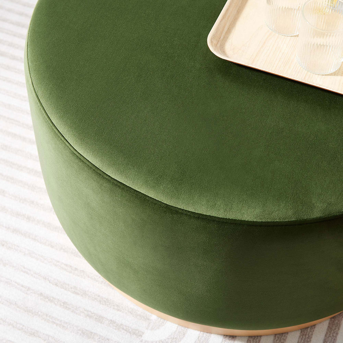 Moss green velvet ottoman styled as a coffee table with tray and drinks on a soft striped area rug. || EEI-6648-MOG-NAT || detail_room