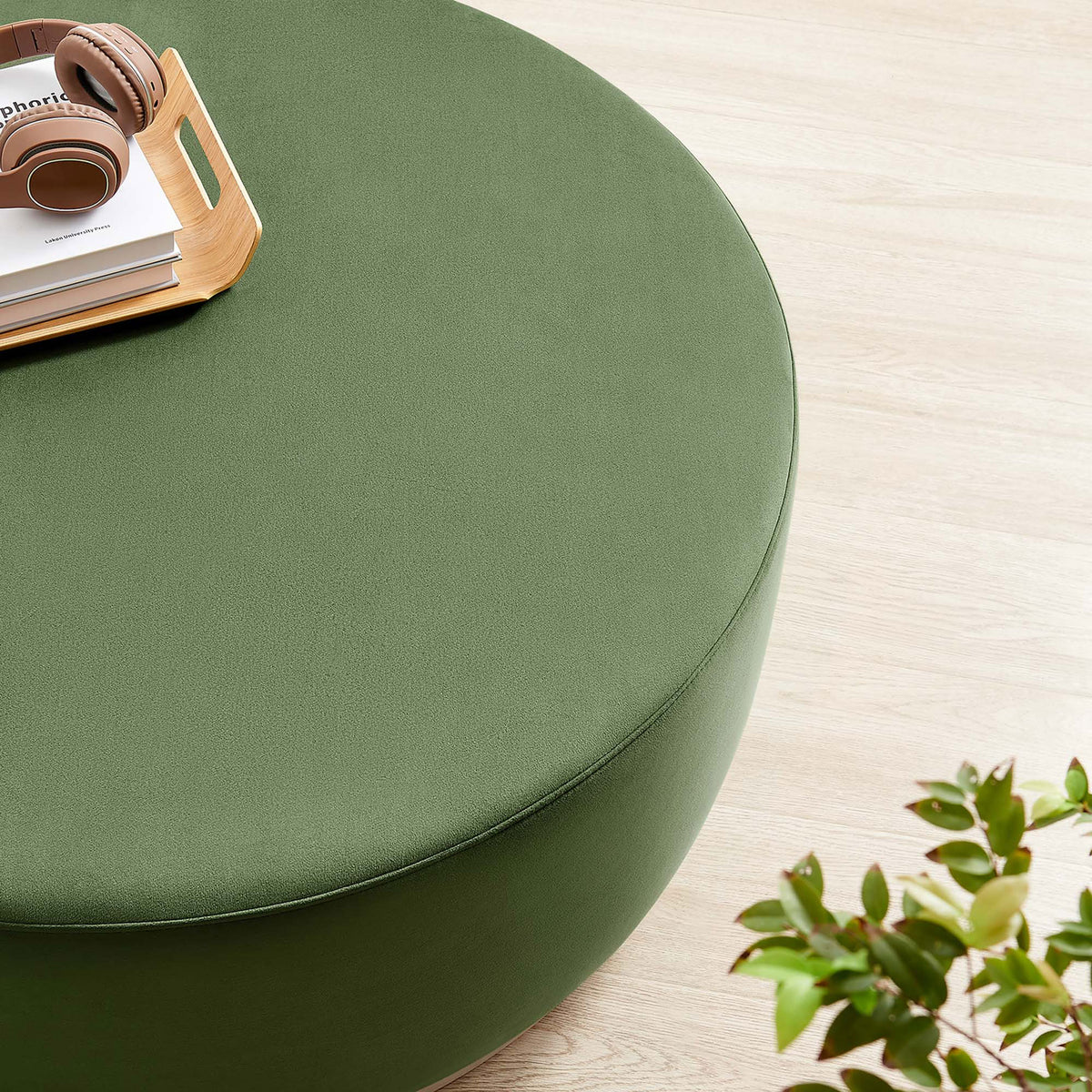 Moss green velvet ottoman styled with a tray and headphones, creating a relaxed modern corner for lounging. || EEI-6650-MOG-NAT || detail_room