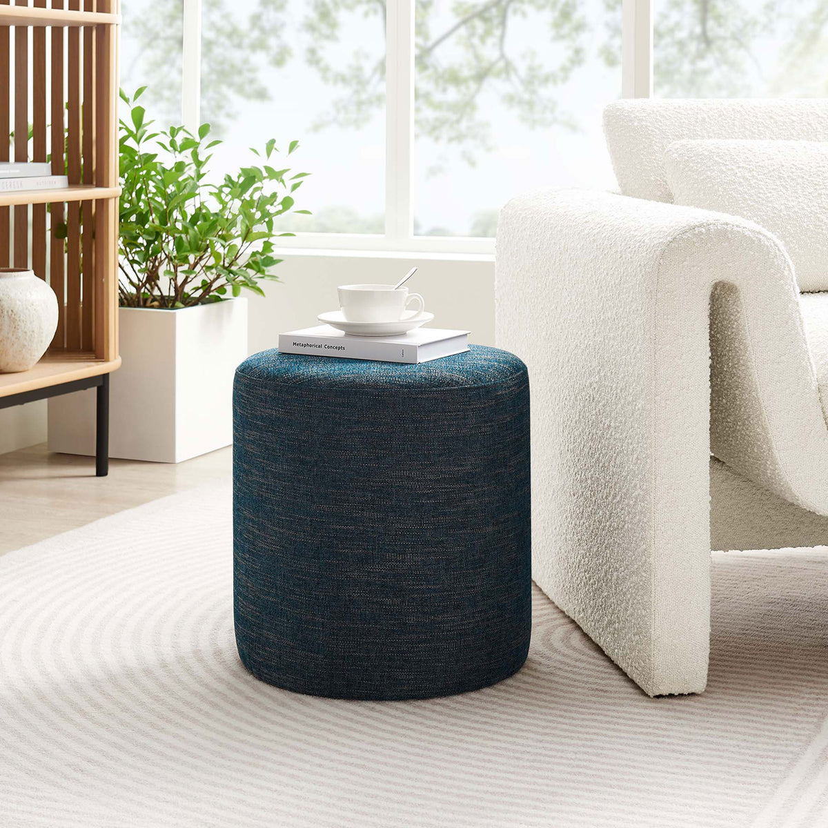 Heathered blue ottoman adds a cozy accent and extra surface beside a contemporary living room chair || EEI-6651-HEA || front_angle_room