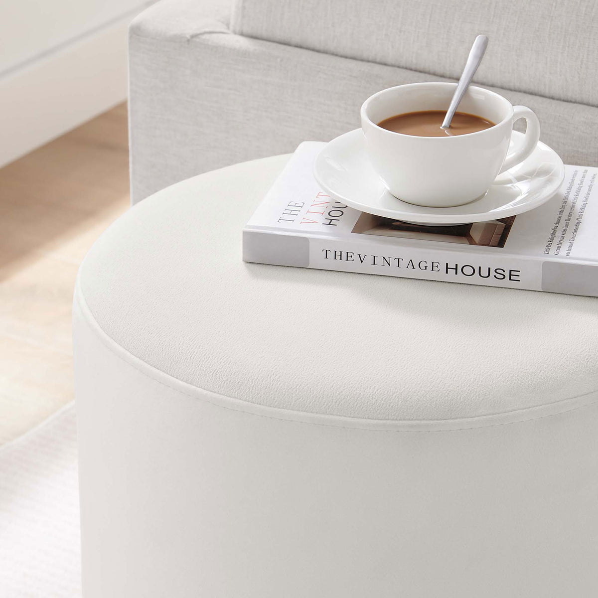 Round alabaster ottoman doubles as a chic surface for coffee and books in a bright living room || EEI-6652-ALA-NAT || detail_room