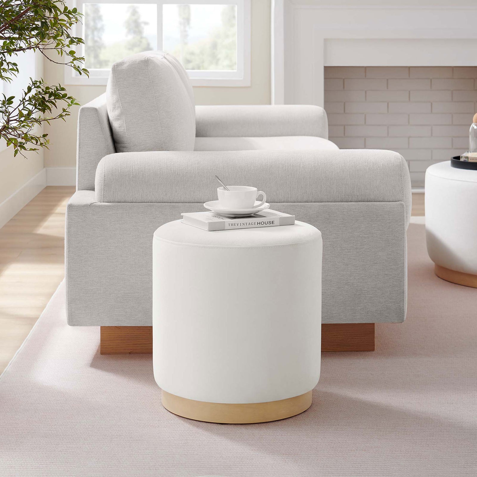 Alabaster round ottoman adds soft texture and extra seating beside a modern sofa in a cozy living room || EEI-6652-ALA-NAT || front_room