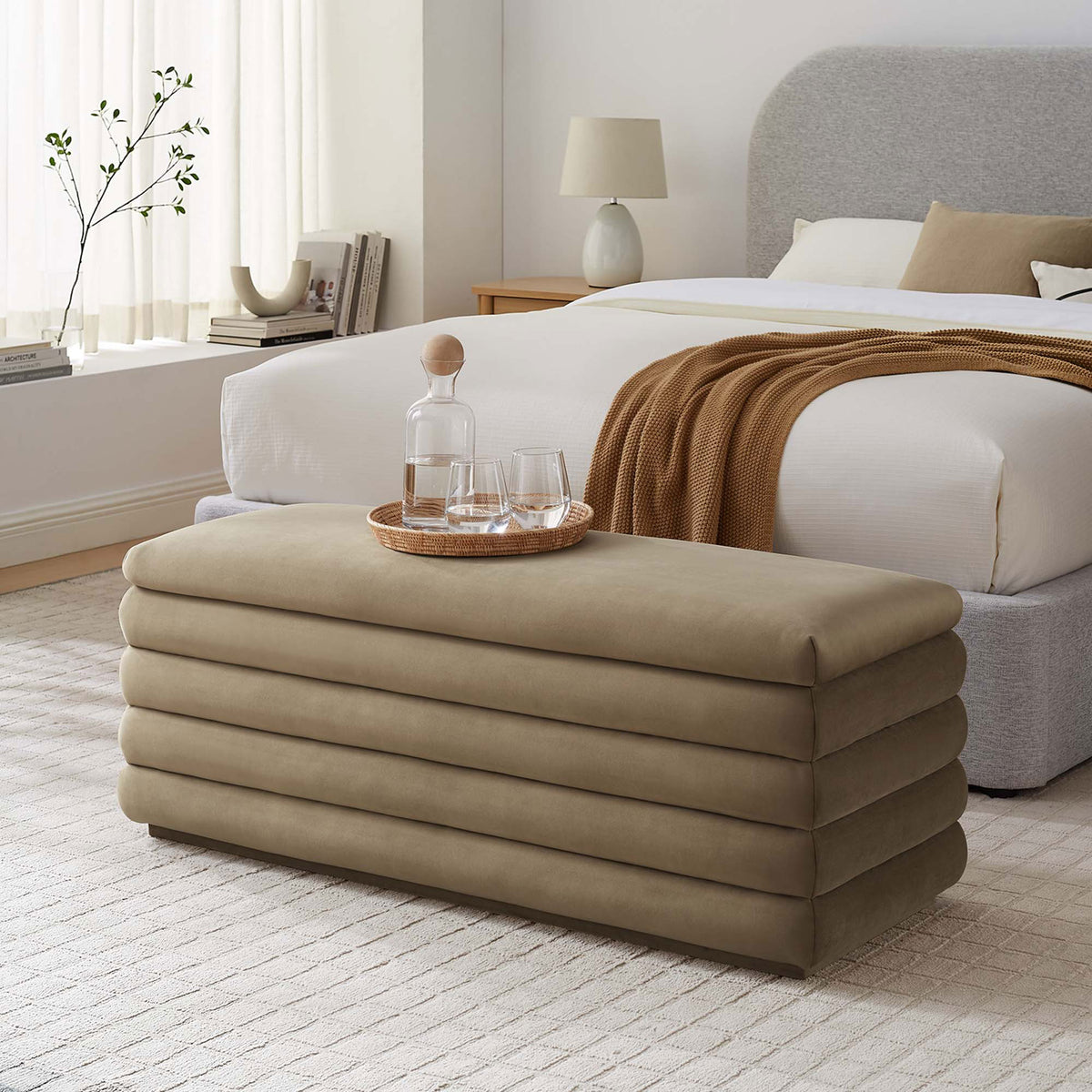 Plush channel-tufted bench complements bedroom decor with soft taupe velvet and rounded edges. || EEI-6664-TAU || front_angle_room