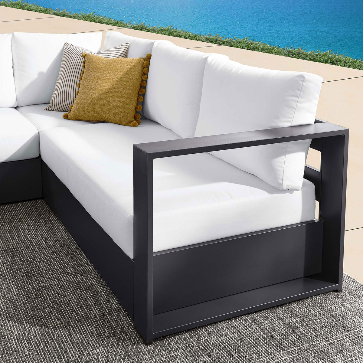 White armrest detail highlights the sectionals open-frame arm design and plush outdoor cushions by the pool || EEI-6668-GRY-WHI || detail_room