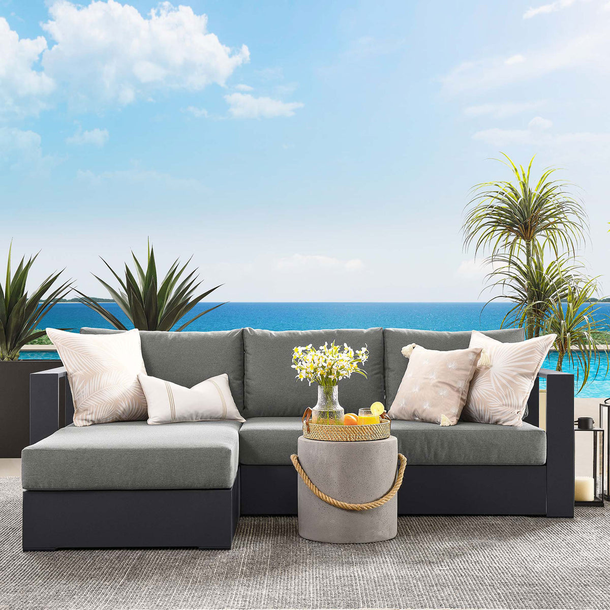 Left-chaise Tahoe sectional styled on a poolside patio with soft charcoal cushions and decor || EEI-6670-GRY-CHA || front_angle_room