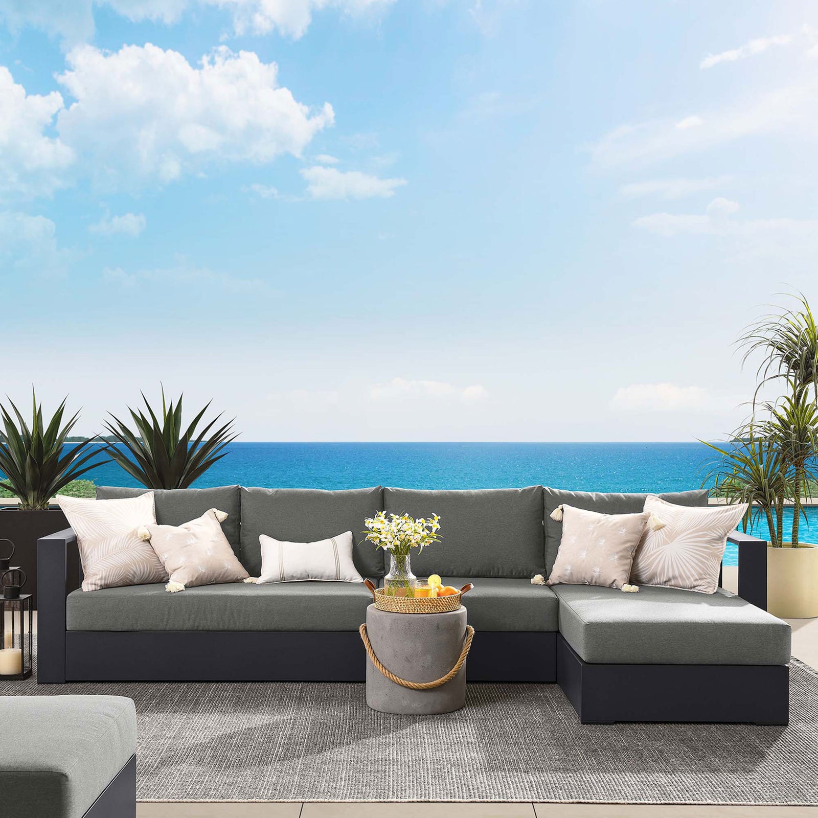 Right chaise sectional arranged on a coastal patio with ocean horizon, lanterns, and soft neutral cushions || EEI-6671-GRY-CHA || front_room