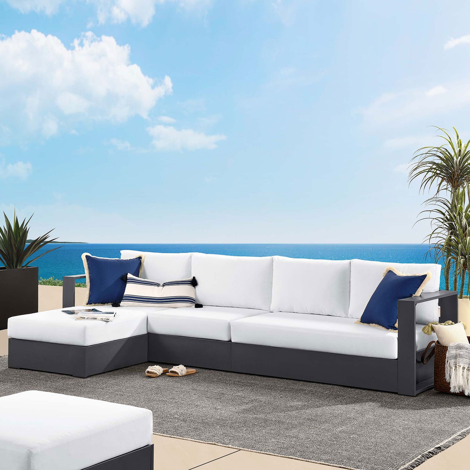 Left chaise sectional on a terrace by the water, styled with navy pillows and casual coastal decor || EEI-6672-GRY-WHI || front_angle_room