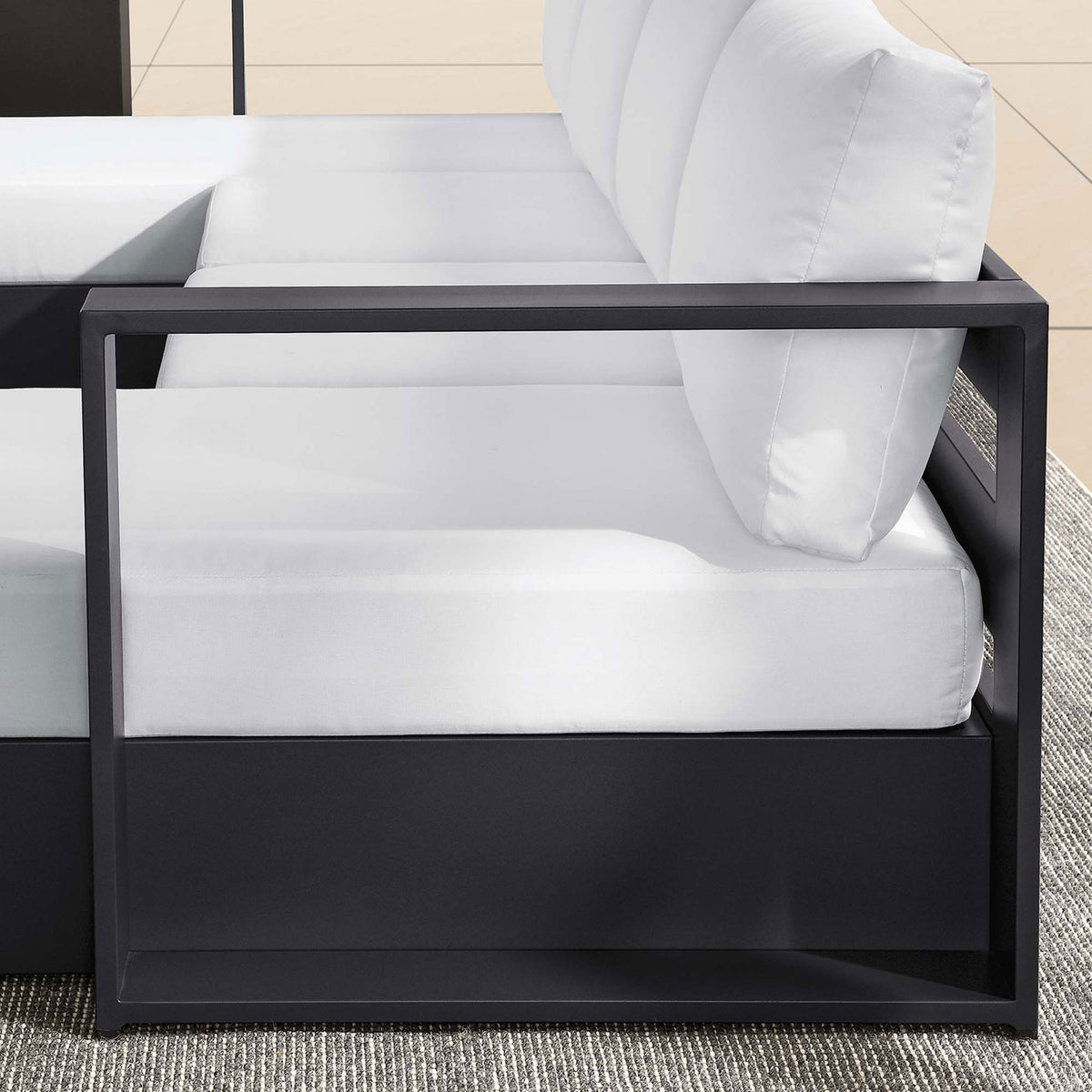 Linear metal arm and white cushions giving the Tahoe outdoor sectional a crisp, tailored architectural profile || EEI-6676-GRY-WHI || detail_room