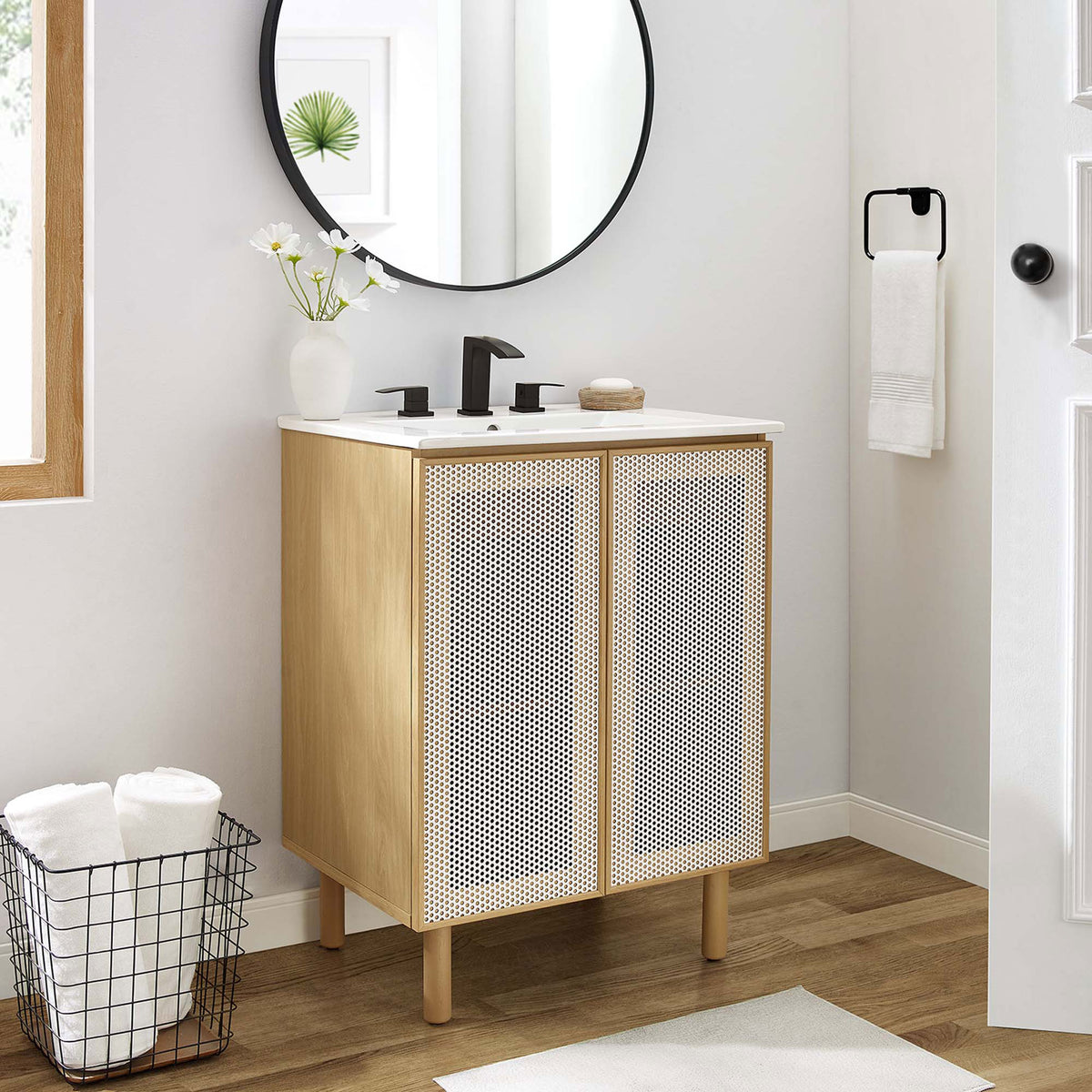 Modern vanity pairs warm oak grain with airy perforated doors and a bright ceramic sink. || EEI-6677-WHI-OAK || front_angle_room