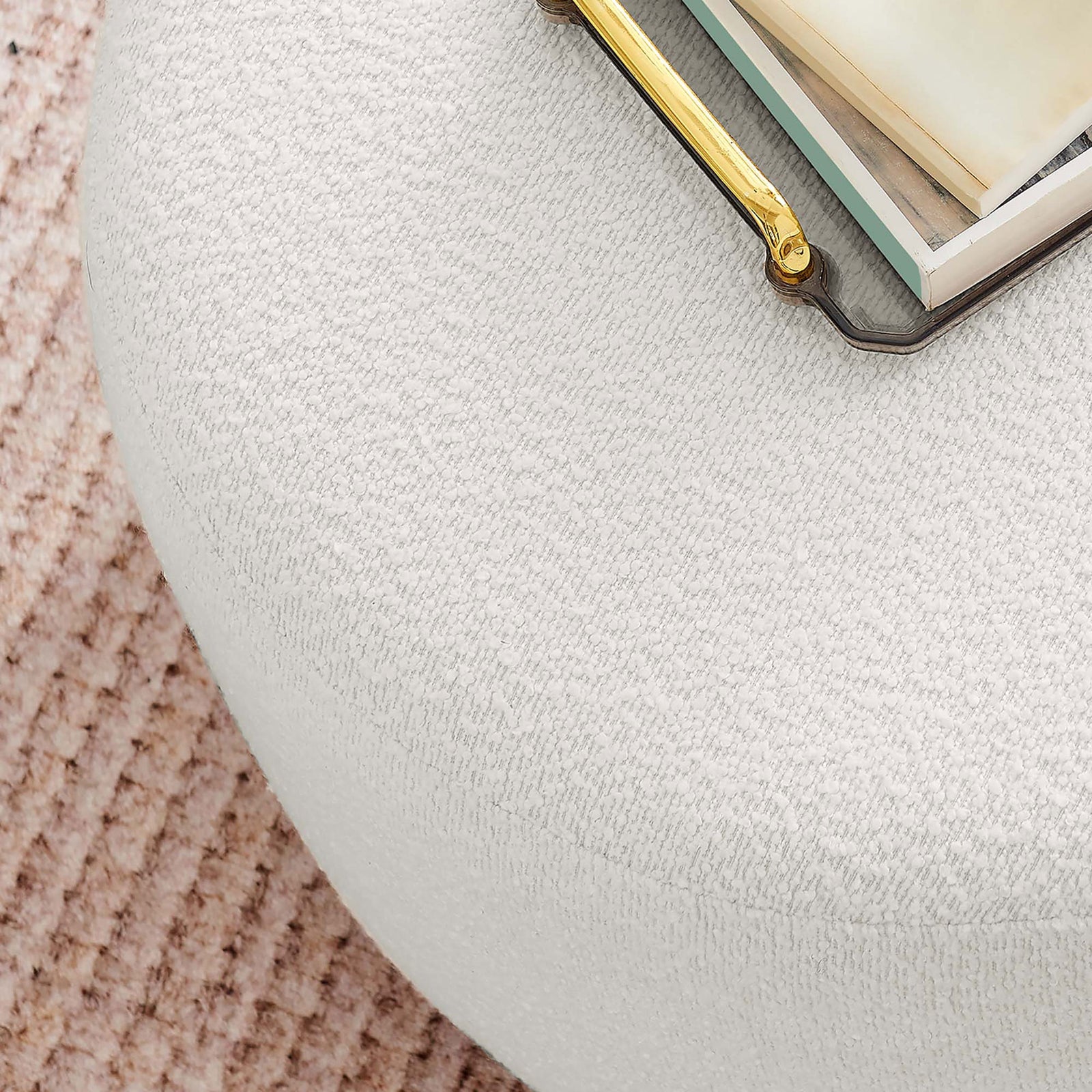 Boucle ottoman styled on a textured blush rug with books and gold-tone tray for an inviting vignette || EEI-6683-CLO-WAL || detail_room