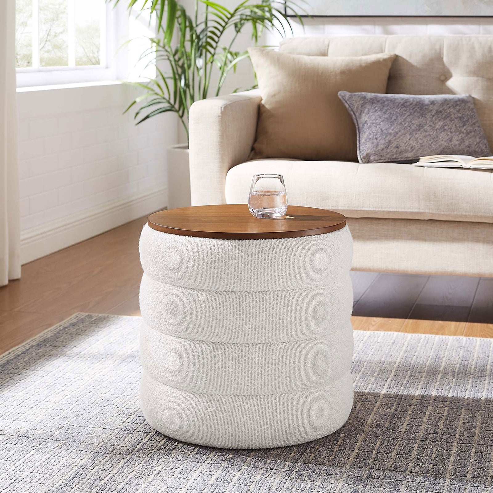 Modern living room with a cloud boucle storage ottoman on a textured rug serving as a side table || EEI-6685-CLO || front_angle_room