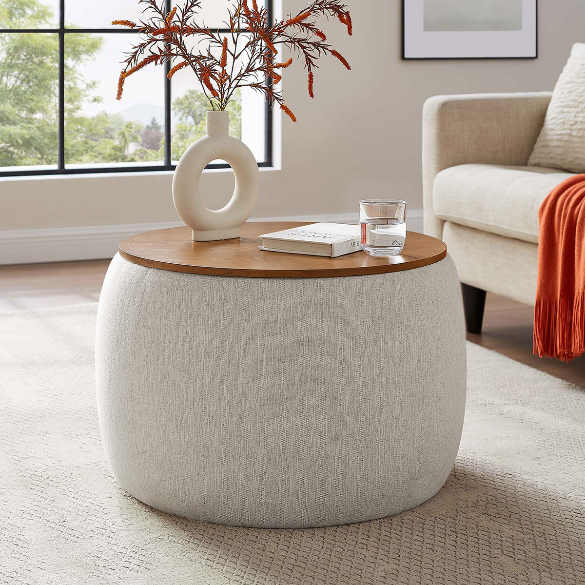 Ivory Perla storage ottoman serving as a coffee table beside a modern sofa in a bright living room || EEI-6688-HEI || front_angle_room