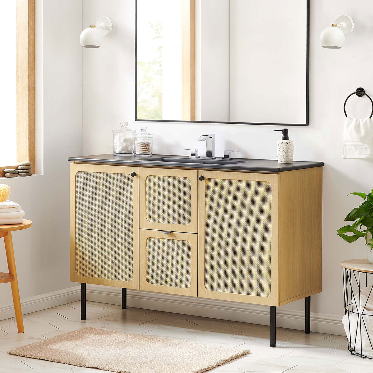 Clean-lined vanity anchors the bath with airy rattan doors and a bold black countertop || EEI-6700-OAK-BLK || front_room