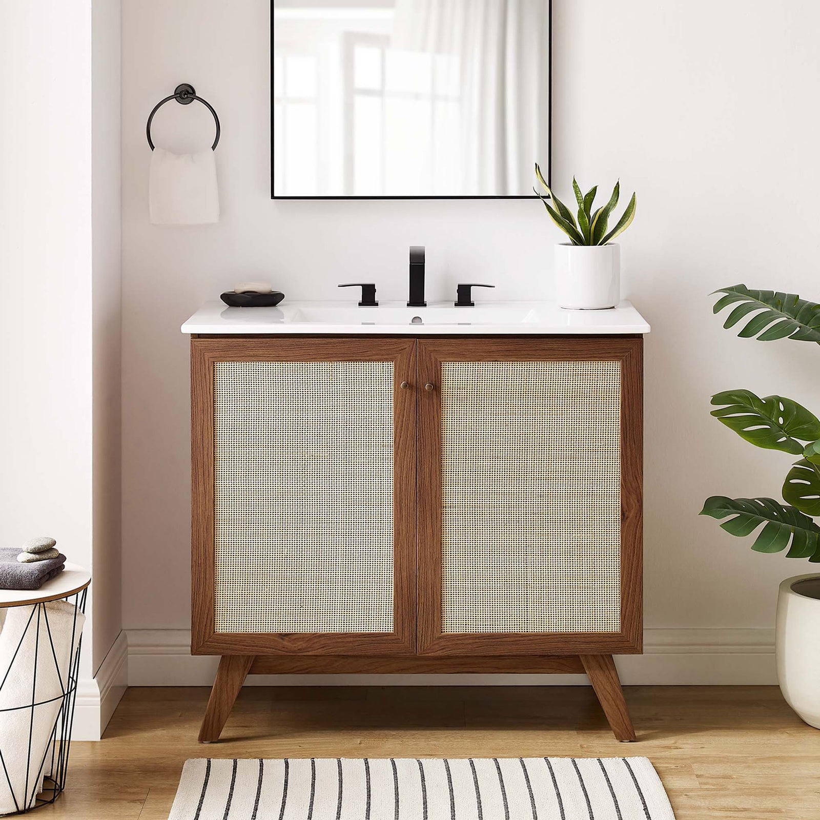 Warm walnut tones and airy caning elevate this vanity in a bright, inviting bath || EEI-6717-WAL-WHI || front_room