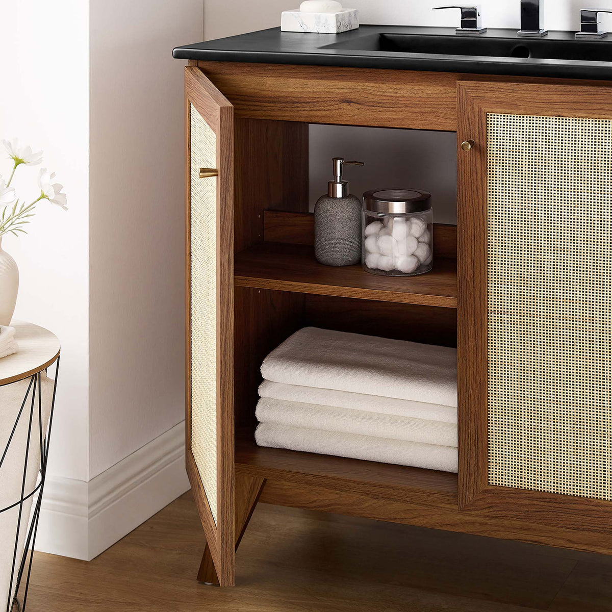 Interior shelf keeps linens and bottles tidy behind the textured cane doors. || EEI-6718-WAL-BLK || storage_open_room
