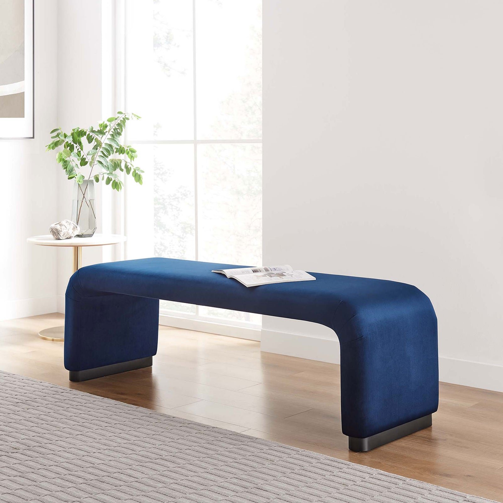 Sculptural velvet bench elevates the living space with its flowing lines and refined black base || EEI-6734-BLK-MID || front_angle_room