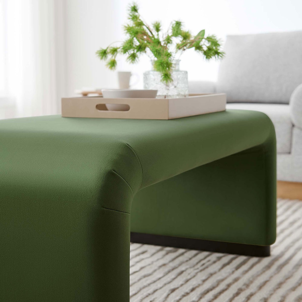 Waterfall ottoman in black moss green velvet styled as a coffee table with tray in a bright modern living room || EEI-6735-BLK-MOS || front_angle_room