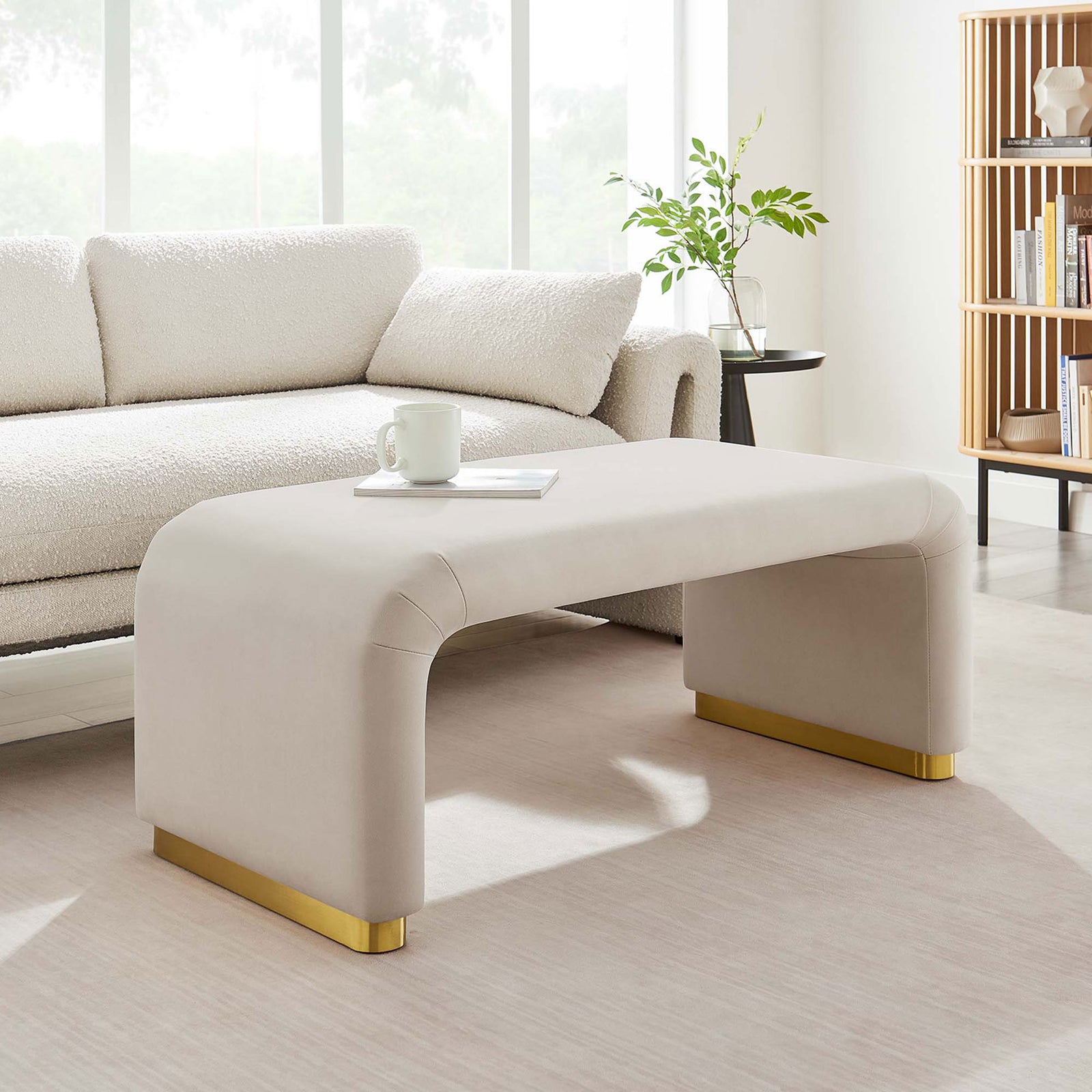 Bright living space showcasing the Koda performance velvet ottoman as a chic coffee table in front of a cozy sofa || EEI-6735-BRA-ALM || front_room
