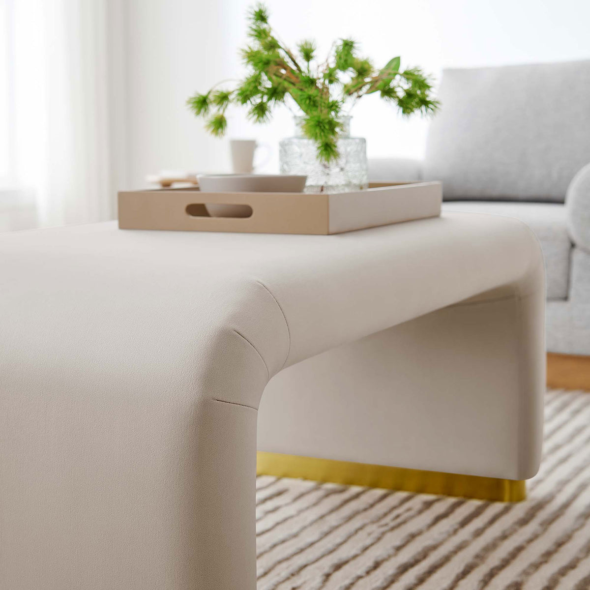 Koda ottoman styled as a coffee table with tray, drinks, and decor on the soft waterfall velvet top || EEI-6735-BRA-ALM || detail_room
