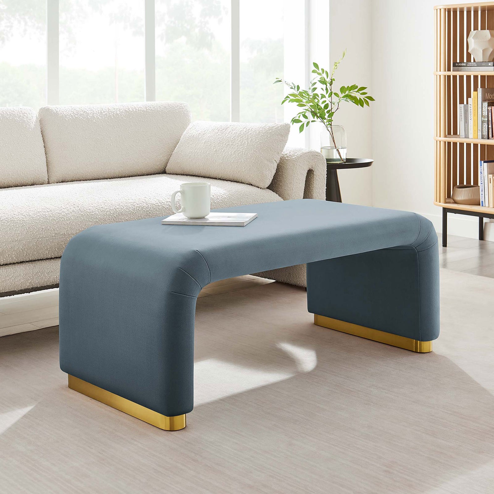 Versatile Koda waterfall ottoman functions as stylish seating or a low-profile coffee table in a bright lounge. || EEI-6735-BRA-CAB || front_angle_room