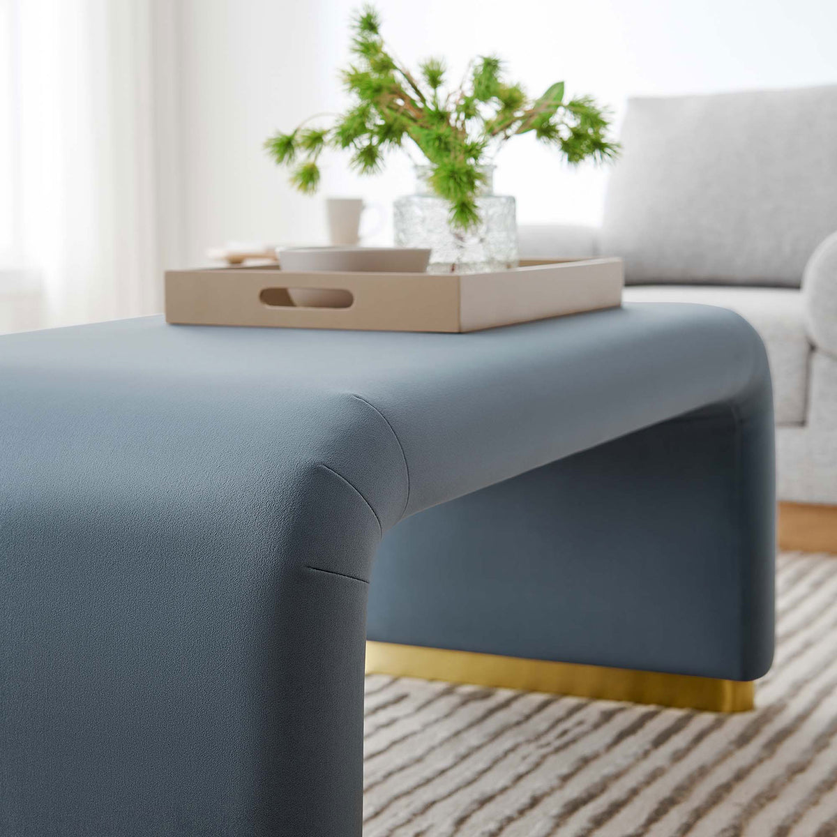 Cadet blue waterfall ottoman styled as a coffee table adds soft color and shine to a cozy living room. || EEI-6735-BRA-CAB || front_angle_room